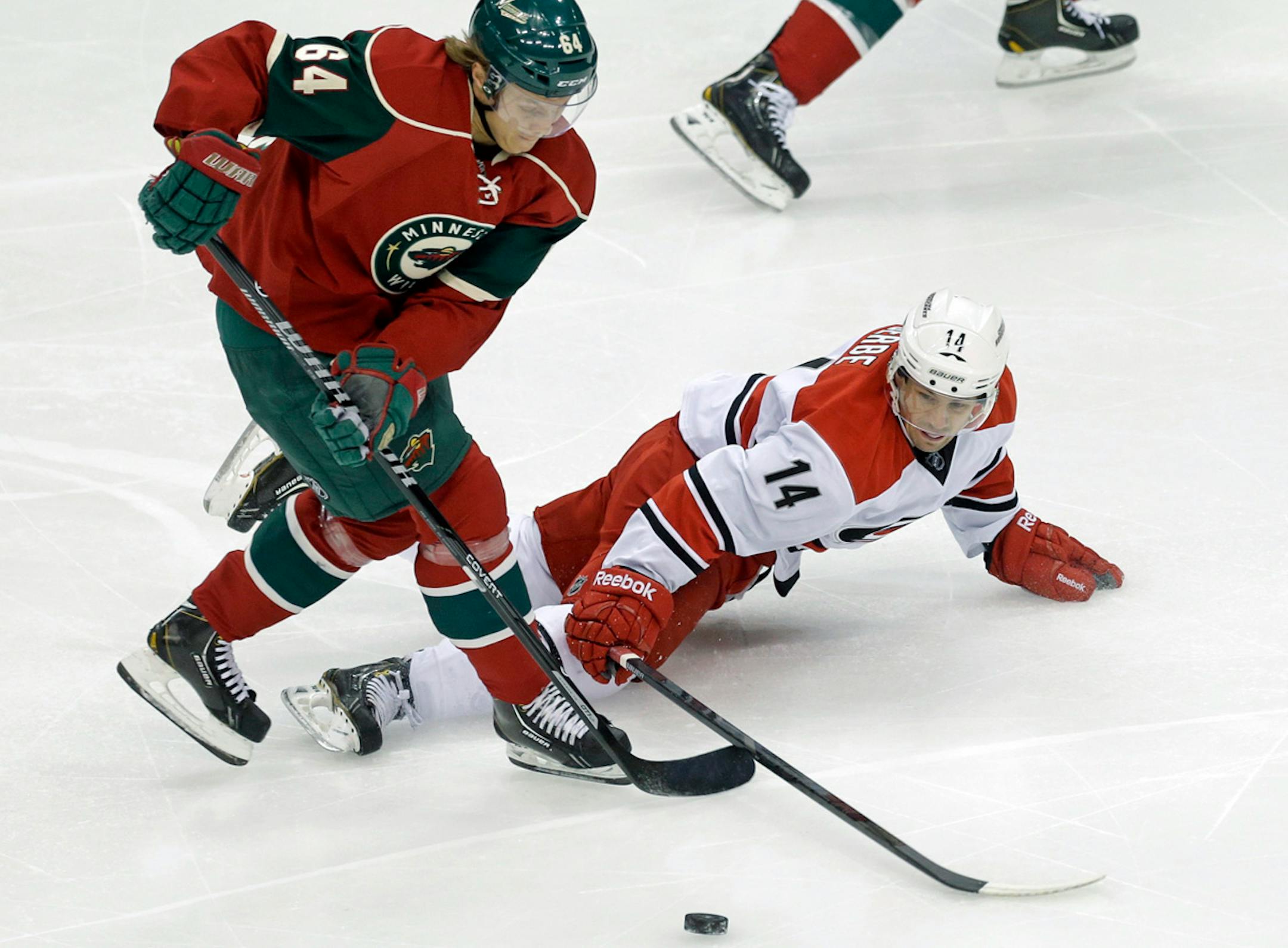 Carolina Hurricanes' Nathan Gerbe, right, tries to reach the puck as Minnesota Wild's Mikael Granlund takes it in the first period of an NHL hockey game Thursday, Oct. 24, 2013, in St. Paul, Minn. (AP Photo/Jim Mone)