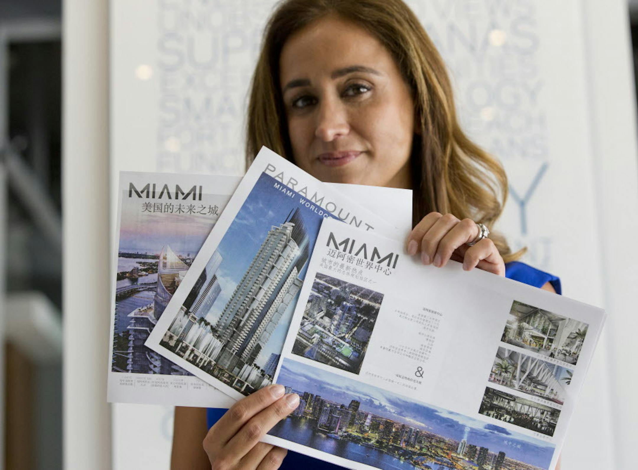 Peggy Fucci, CEO of OneWorld Properties, holds brochures written in Chinese for the Paramount Miami Worldcenter, in Fort Lauderdale, Fla. A nearly 40 percent plunge in the Shanghai stock market since mid-June has sent Chinese investors looking for safer investments. Some are focusing on U.S. real estate, including the condos Fucciís real estate brokerage sells in Miami. Sheís sold six condos to Chinese buyers in the past month, twice the number sheís typically sold. (AP Photo/Wilf