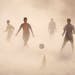 Aspiring young Indian soccer players continue with their practice during a dust storm in Jammu, India, Wednesday, June 11, 2014. Soccer fans around th