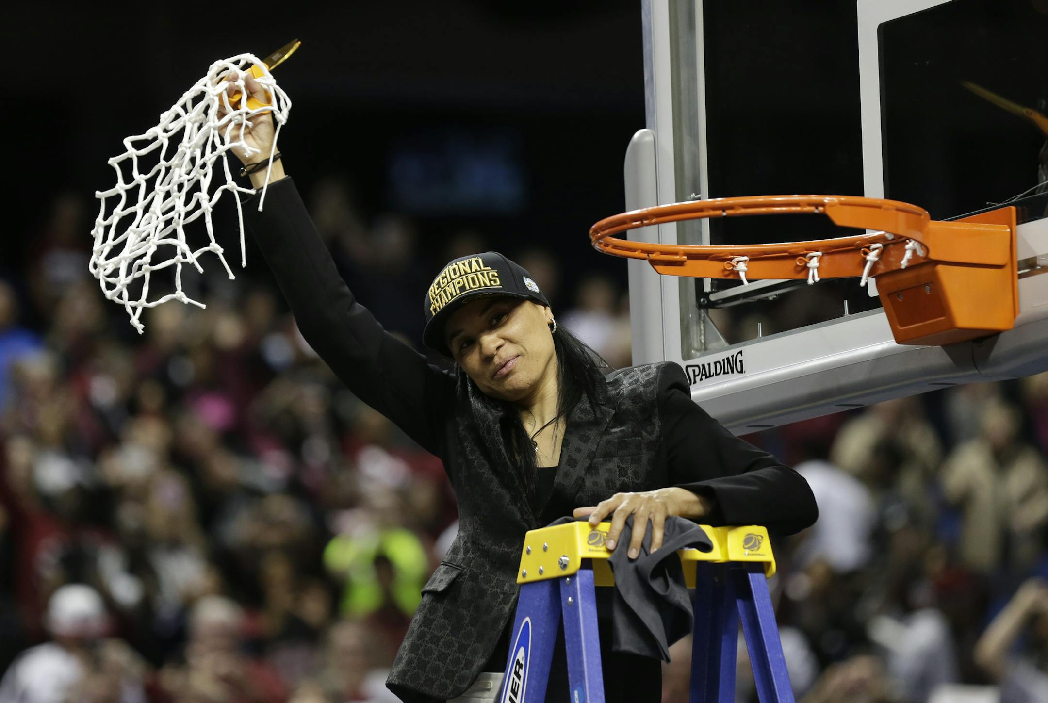 South Carolina coach Dawn Staley holds the net following a women's college basketball regional final game against Florida State in the NCAA Tournament in Greensboro, N.C., Sunday, March 29, 2015. South Carolina won 80-74. (AP Photo/Gerry Broome)