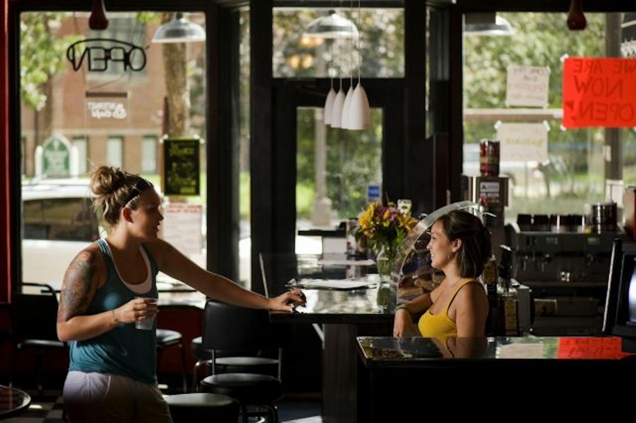 Rudies Coffeehouse on West 7th has reopened after an arson fire last January. Seen here are on right is Bridget Tran, owner, and Jennifer Fleischaker, a neighbor and customer.