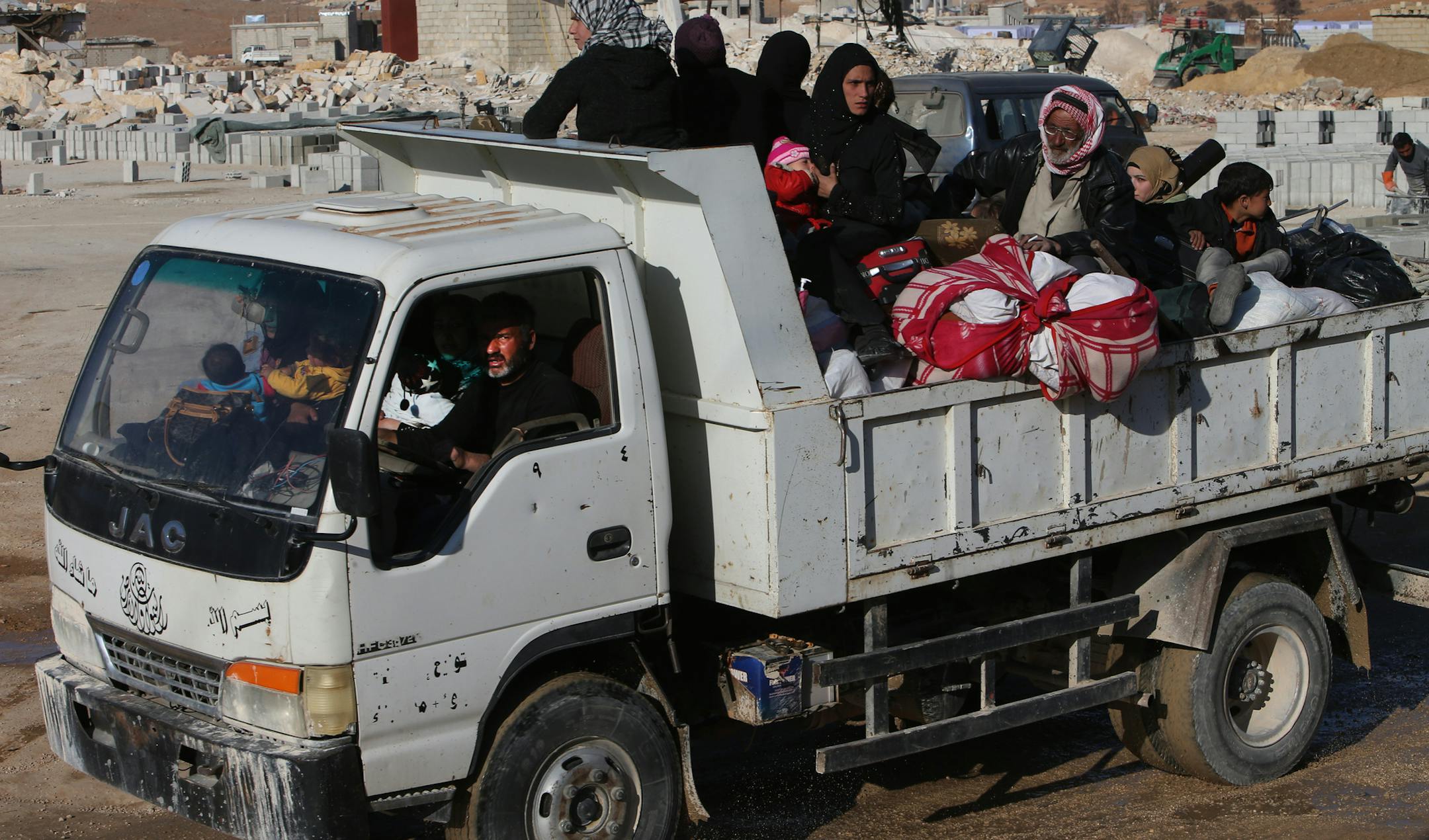 Syrian citizens who fled from Yabroud, the last rebel stronghold in Syria's mountainous Qalamoun region, sit on a truck with their belongings, as they arrive at the Lebanese-Syrian border town of Arssal, eastern Lebanon, Wednesday, Feb. 12, 2014. Syrian warplanes pounded a rebel-held town near the Lebanese border on Wednesday, activists said, as opposition leaders in Geneva called on Russia to put pressure on the government to prevent the faltering peace negotiations from collapsing. (AP Photo/H