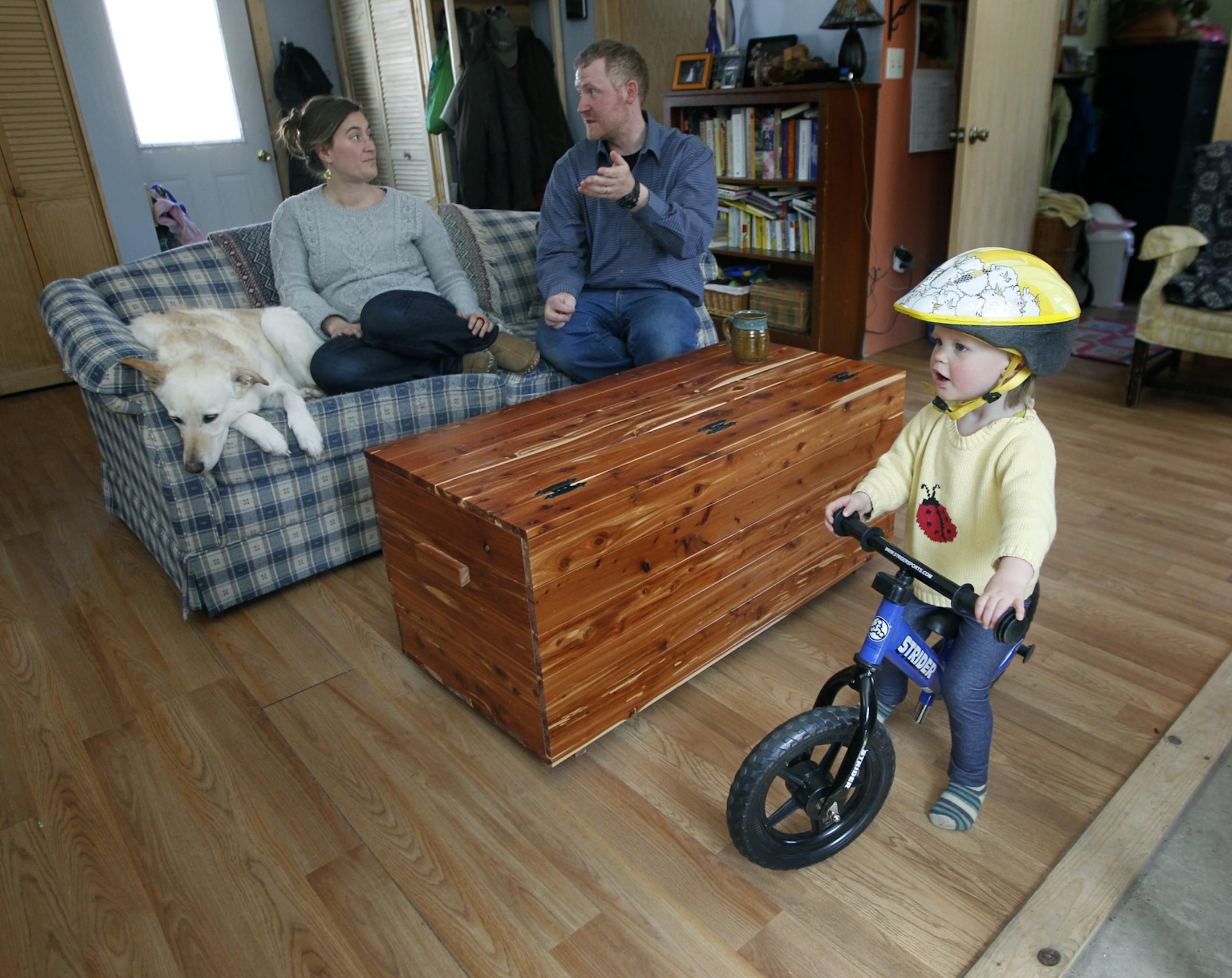 Dave and Amy Demmer watched as their 2-year-old daughter Penelope, rode her bike around their living room, Saturday, April 26, 2014 in Grand Marais, MN. (ELIZABETH FLORES/STAR TRIBUNE) ELIZABETH FLORES • eflores@startribune.com