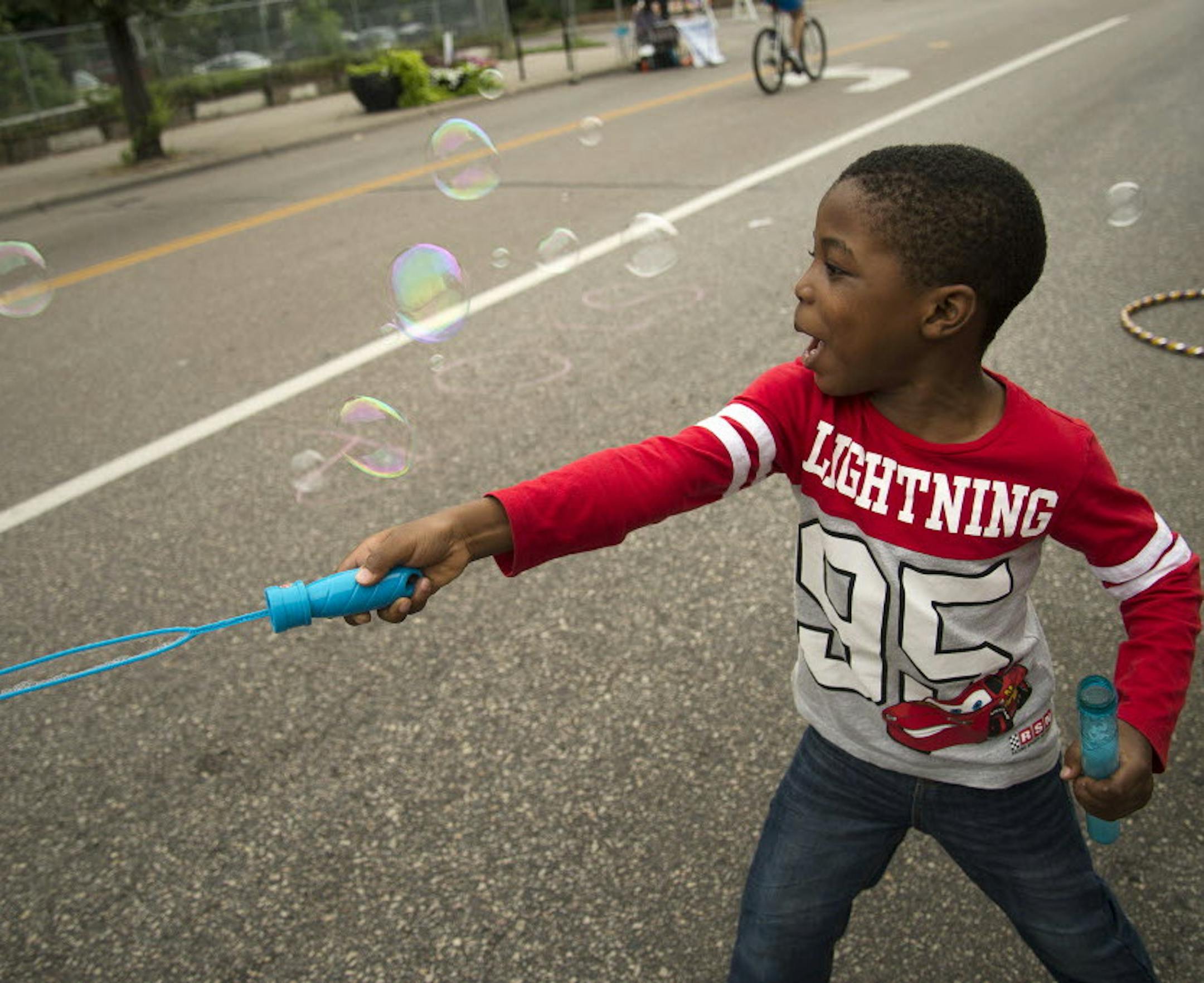 Abud Qodiri Bolarinwa, 5, of Minneapolis, played with bubbles at the "sPARKit" pop-up park during Open Streets Minneapolis on E. Franklin Av in Minneapolis, Minn. on Sunday August 16, 2015. ] RACHEL WOOLF · rachel.woolf@startribune.com Rachel Woolf