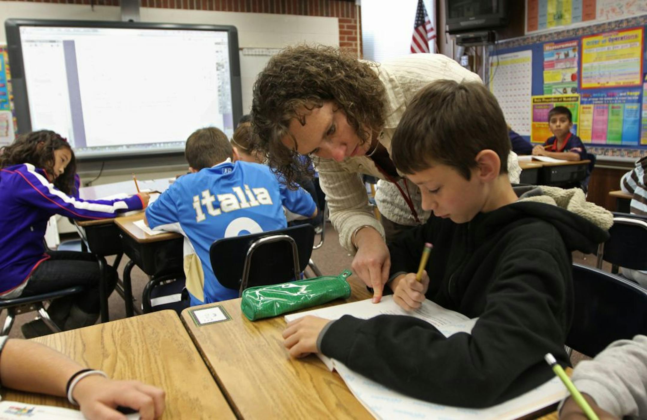 (left to right) Lake Elmo Elementary School Teacher Emily Heilhecker helped 5th grader Eric Faust with math problems during her class on 9/23/11. Stillwater elementary teachers began this year video taping their classes for online access. The program allows for students to watch classroom lectures at home and do their homework in the classroom, a "flipped" concept to traditional classrooms. Bruce Bisping/Star Tribune. Emily Heilhecker, Eric Faust/source.