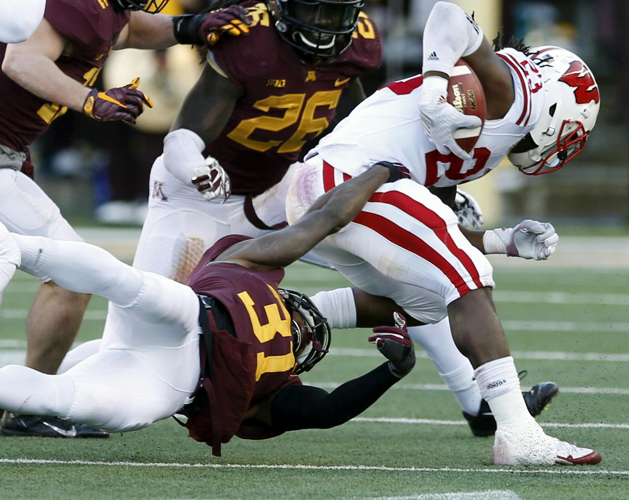Wisconsin running back Dare Ogunbowale, right, tries to break free of Minnesota defensive back Eric Murray (31) in the first half of an NCAA college football game, Saturday, Nov. 28, 2015, in Minneapolis. (AP Photo/Jim Mone)