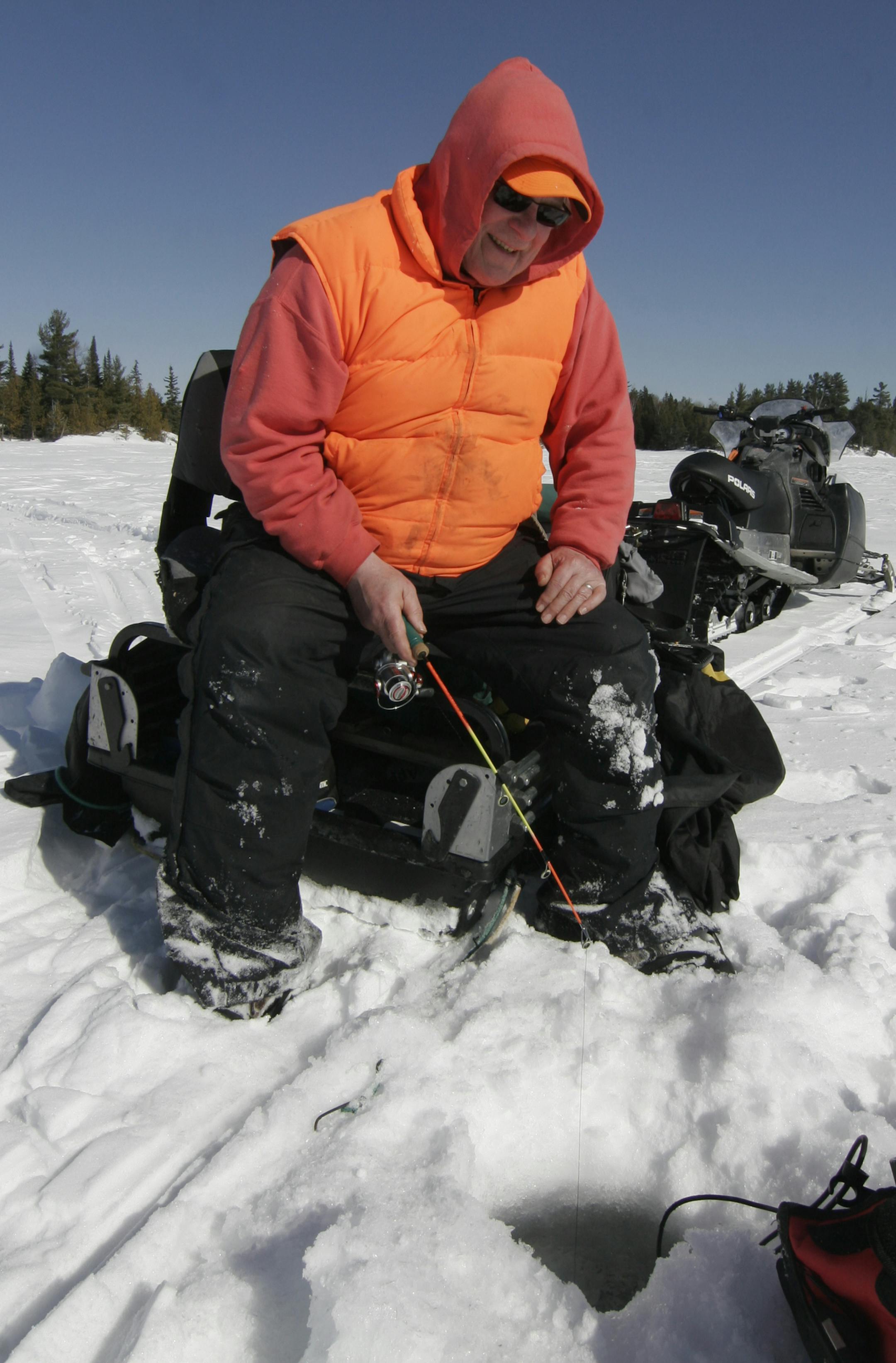 Pete Dzubay of Perham, Minn., sat on his portable fishing shelter and fished outdoors during a warm March day on a remote Ontario lake. Star Tribune photo by Doug Smith