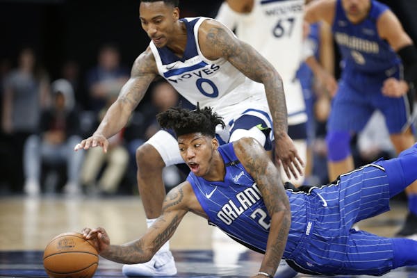 Minnesota Timberwolves guard Jeff Teague (0) and Orlando Magic guard Elfrid Payton (2) chase a loose ball during the second half.