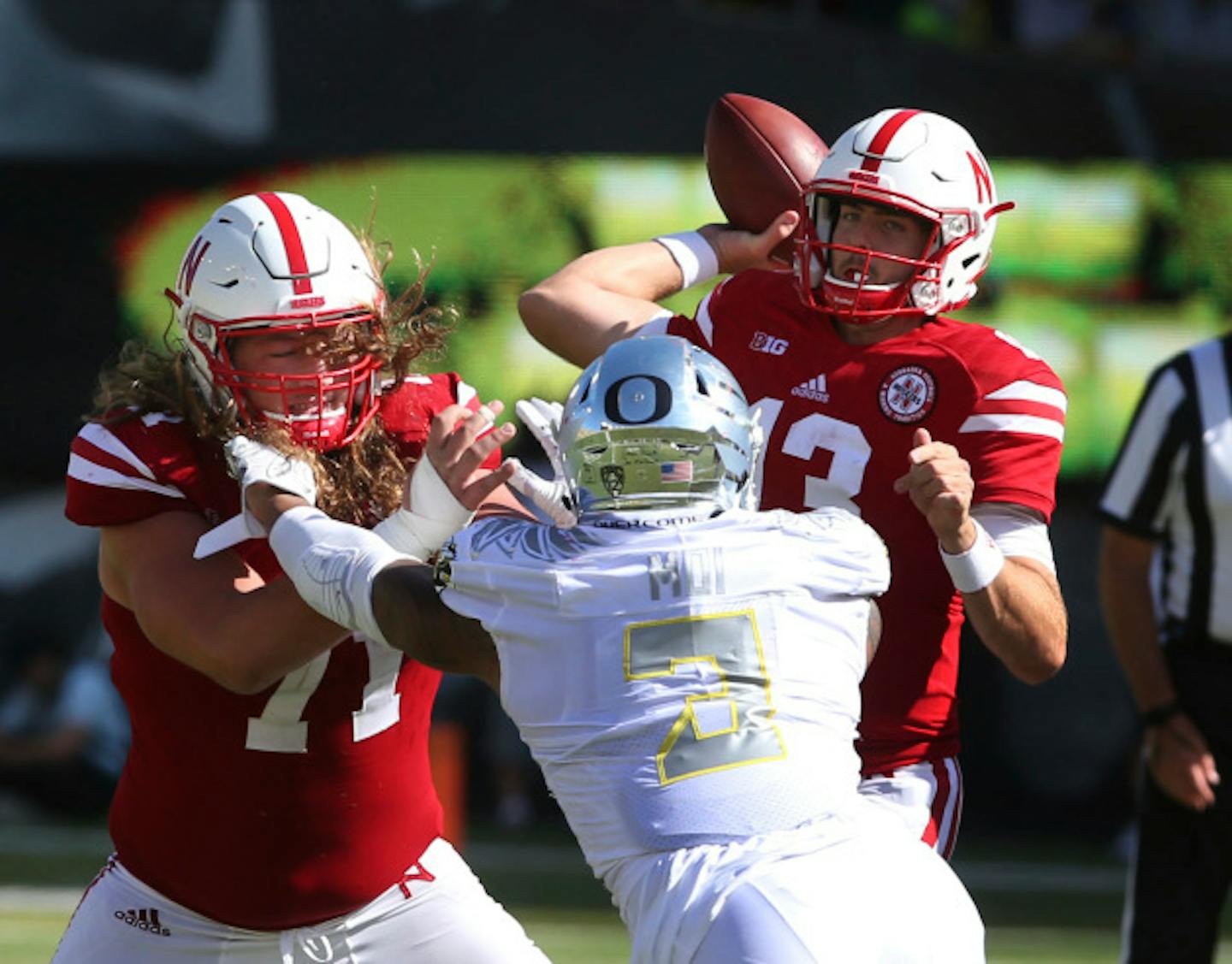 Nebraska Tanner Lee, right, passes against Oregon under pressure during the third quarter of an NCAA college football game Saturday, Sept. 9, 2017, in Eugene, Ore. (AP Photo/Chris Pietsch)