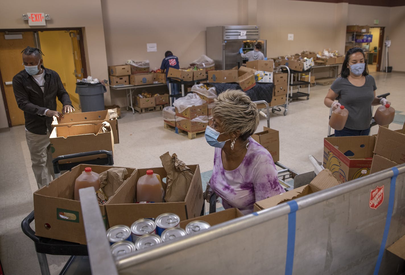 Volunteers Russell Calloway, left, Janie Rogers, center, and Erin Que packed food at a Salvation Army food distribution event at its Citadel service center in St. Paul last week. Some officials cite volunteer fatigue.