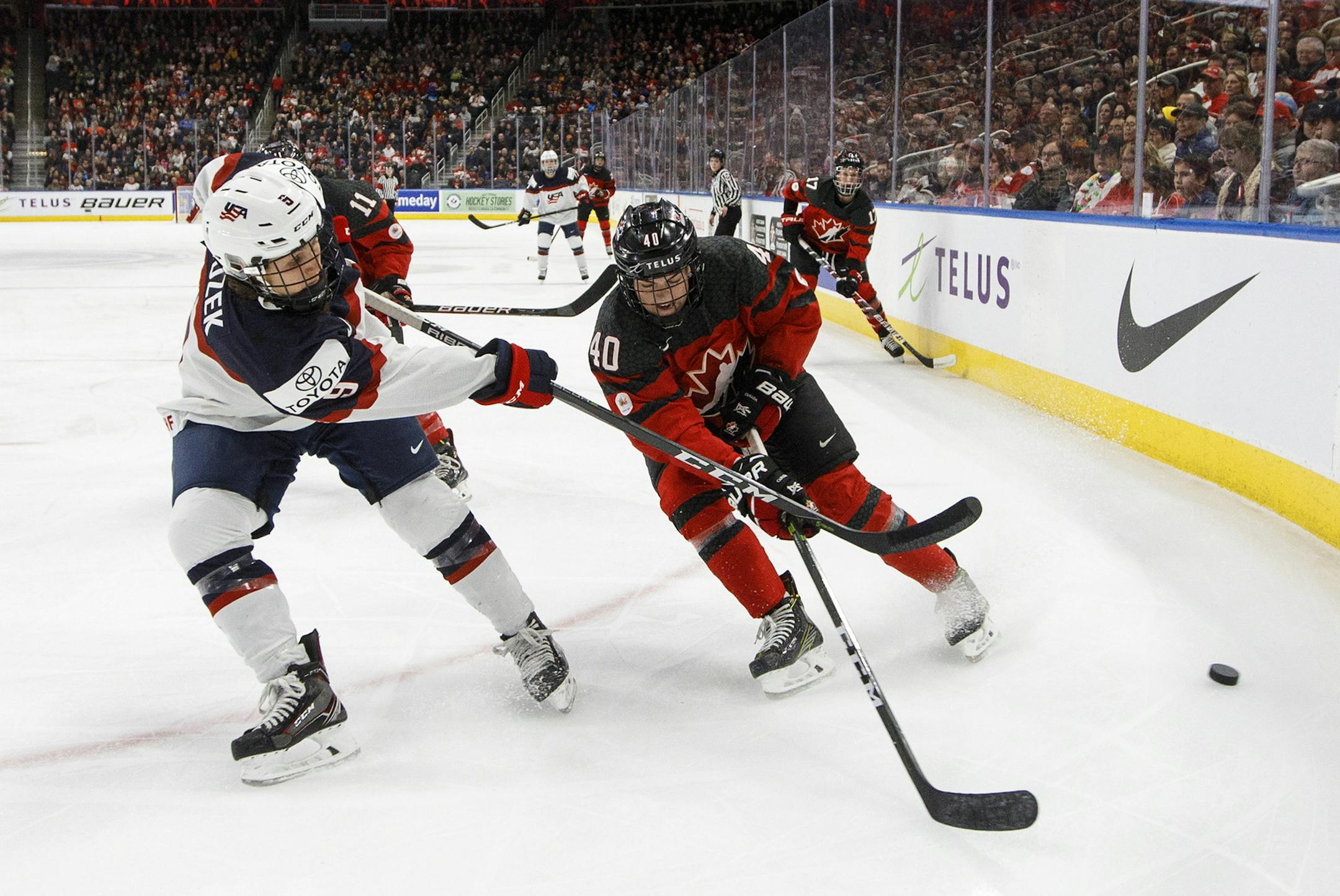 Team Canada's Blayre Turnbull (40) and Team USA's Megan Bozek (9) battle for the puck during second period National Women's Team series hockey action in Edmonton, Alberta, on Sunday Dec. 17, 2017. (Jason Franson/The Canadian Press via AP)
