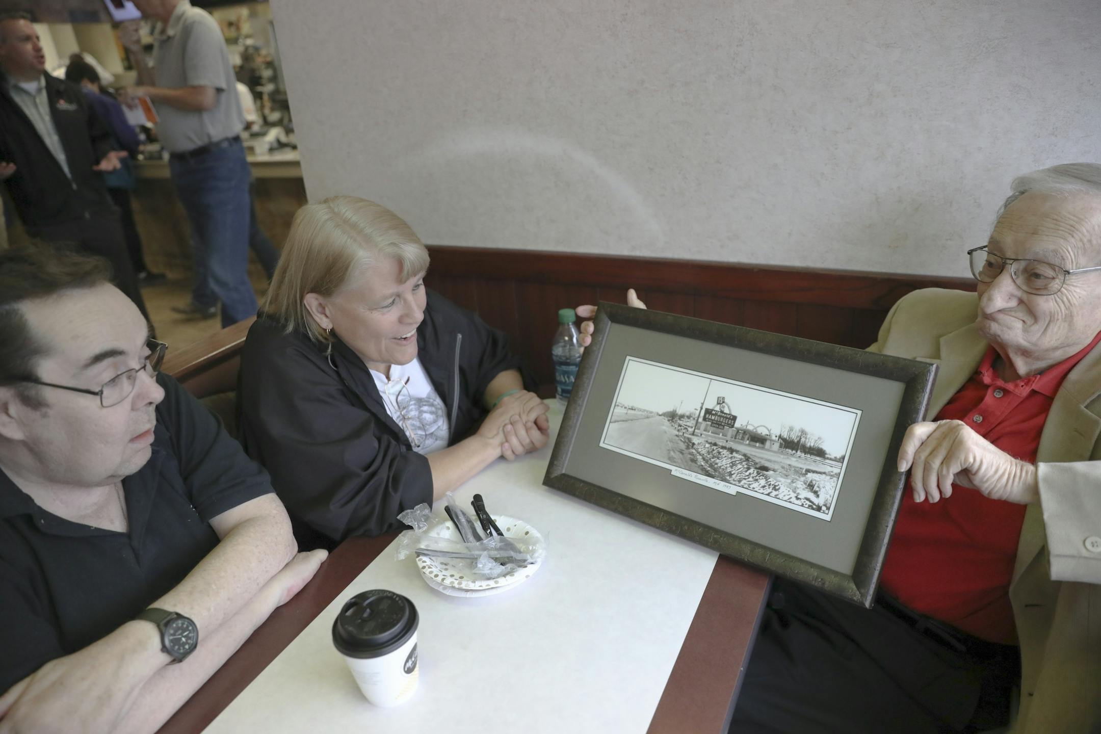 The original bread baker Bob Baldinger, right, held a picture of the original McDonald's while sitting with Robbie Keller and Tim Cody (whose father was the original owner) as they celebrated in the Roseville McDonald's 60th year anniversary. This included sixty cents hamburgers, free cake and throw back uniforms on Monday, September 25, 2017, in Roseville, Minn. This Roseville location was the first McDonald's in Minnesota and 63rd nationwide. Now there are over 14,000 in the U.S.