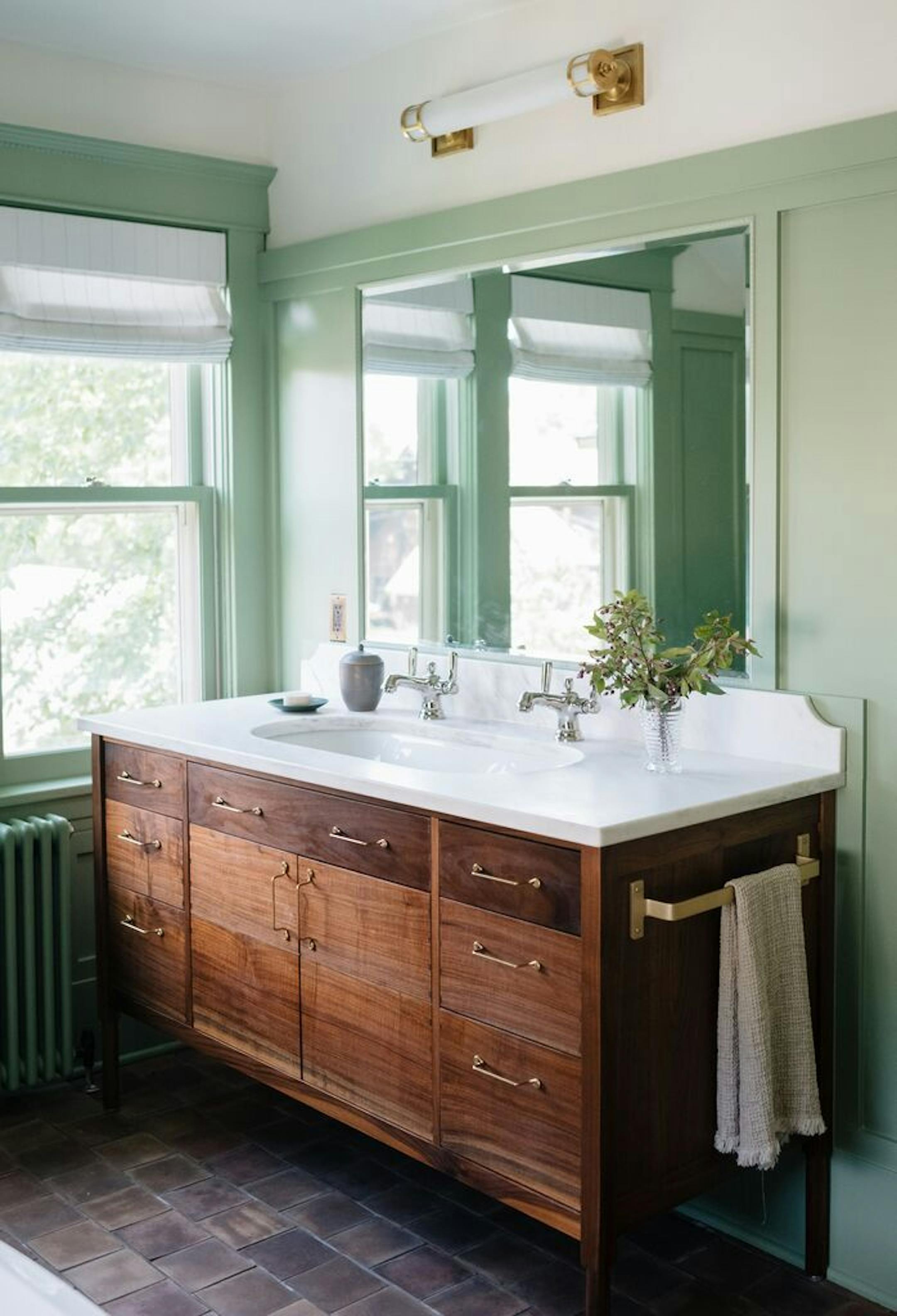 A custom walnut vanity was designed to evoke a piece of furniture.