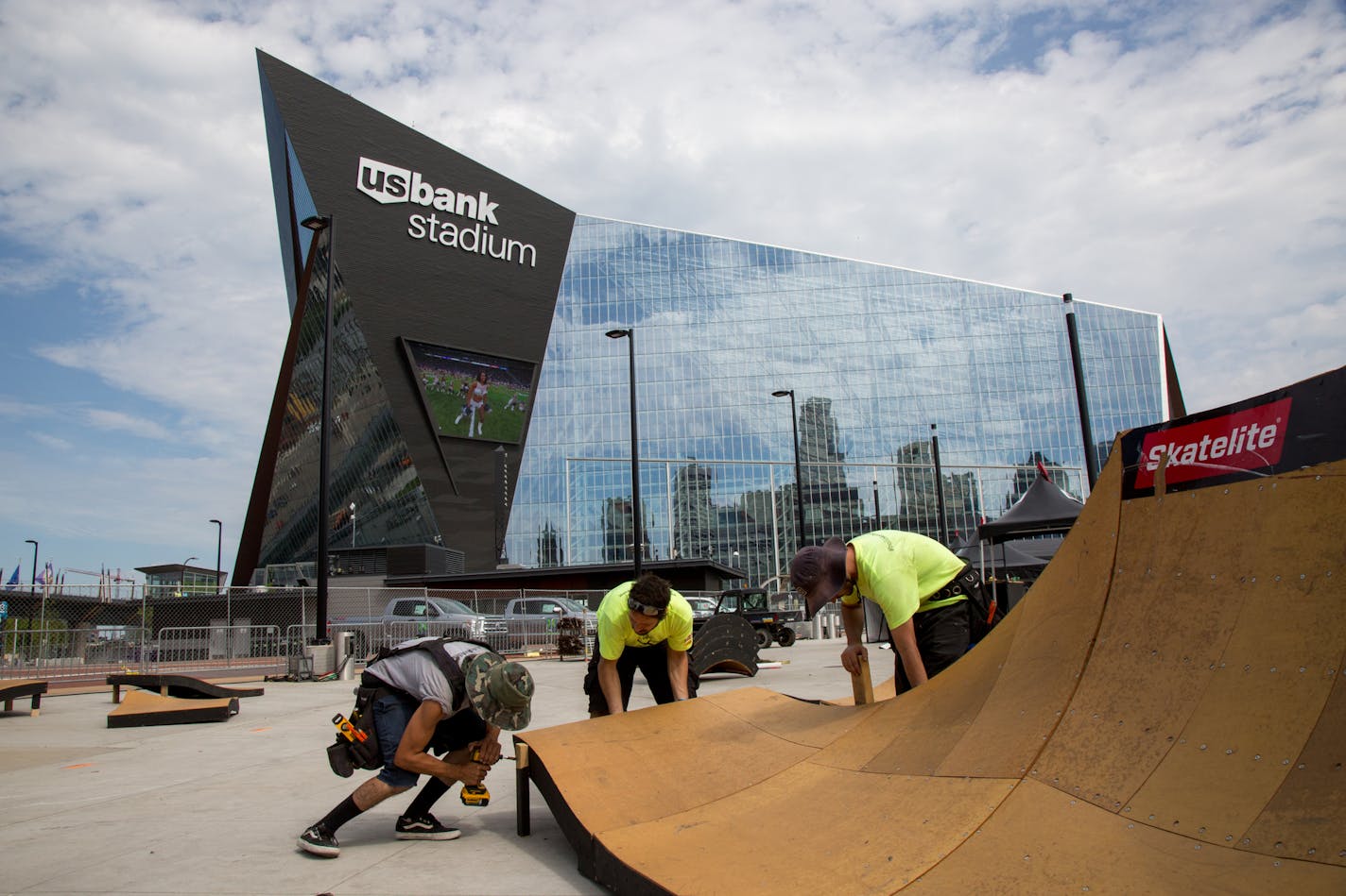 Orlando Lopez, Cesar Lutfi and Daniel Oristanio (from left to right) build a ramp outside of the U.S. Bank Stadium for the X Games, on Sunday. ] COURTNEY PEDROZA &#x2022; courtney.pedroza@startribune.com Sunday, July 9, 2017; X Games; Building ramps; U.S. Bank Stadium