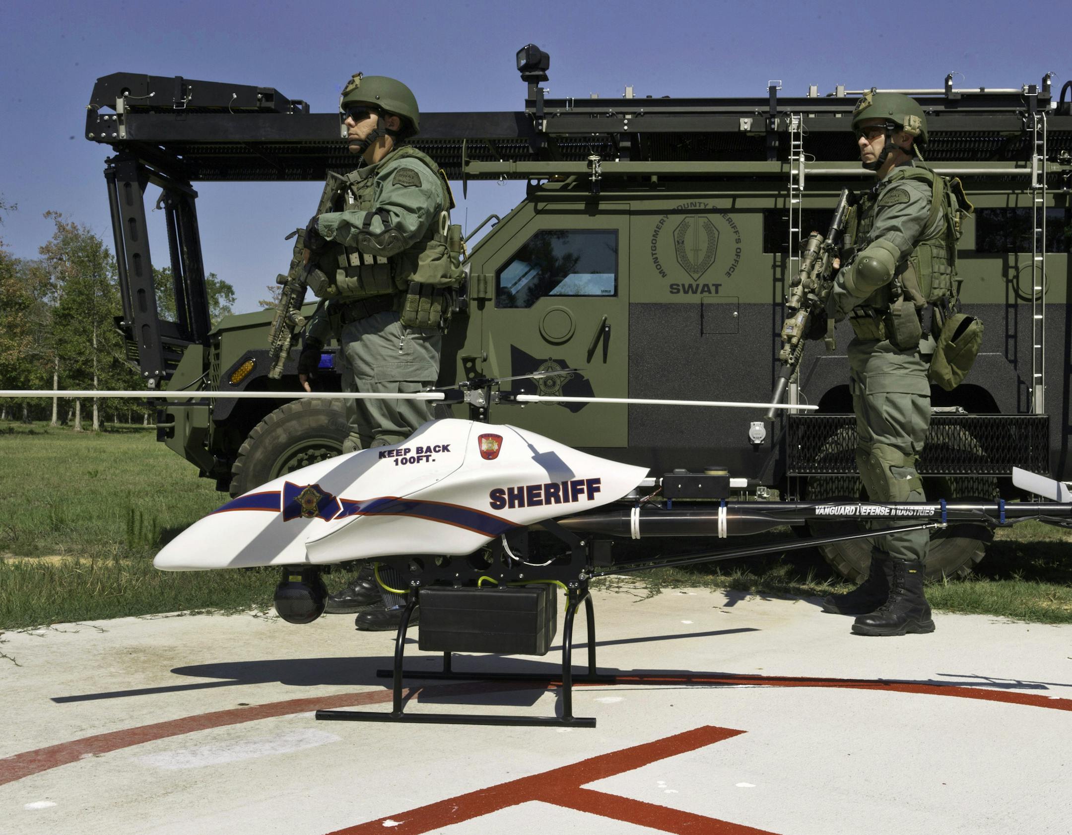 This September 2011 photo provided by Vanguard Defense Industries, shows a ShadowHawk drone with Montgomery County, Texas, SWAT team members. In a major step toward opening U.S. skies to thousands of unmanned drones, federal officials Thursday, Feb. 14, 2013, solicited proposals to create six drone test sites around the country. The FAA has granted several hundred permits to universities, police departments and other government agencies to use small, low-flying drones. For example, the sheriff&#