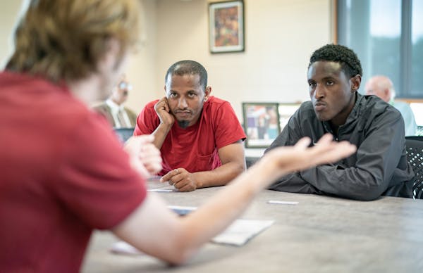 Assistant recruiter Aaron Jennings talked with potential workers Ibsa Mussa, center, and Abdulaziz Abdullah, right. Minneapolis-based nonprofit, Pills