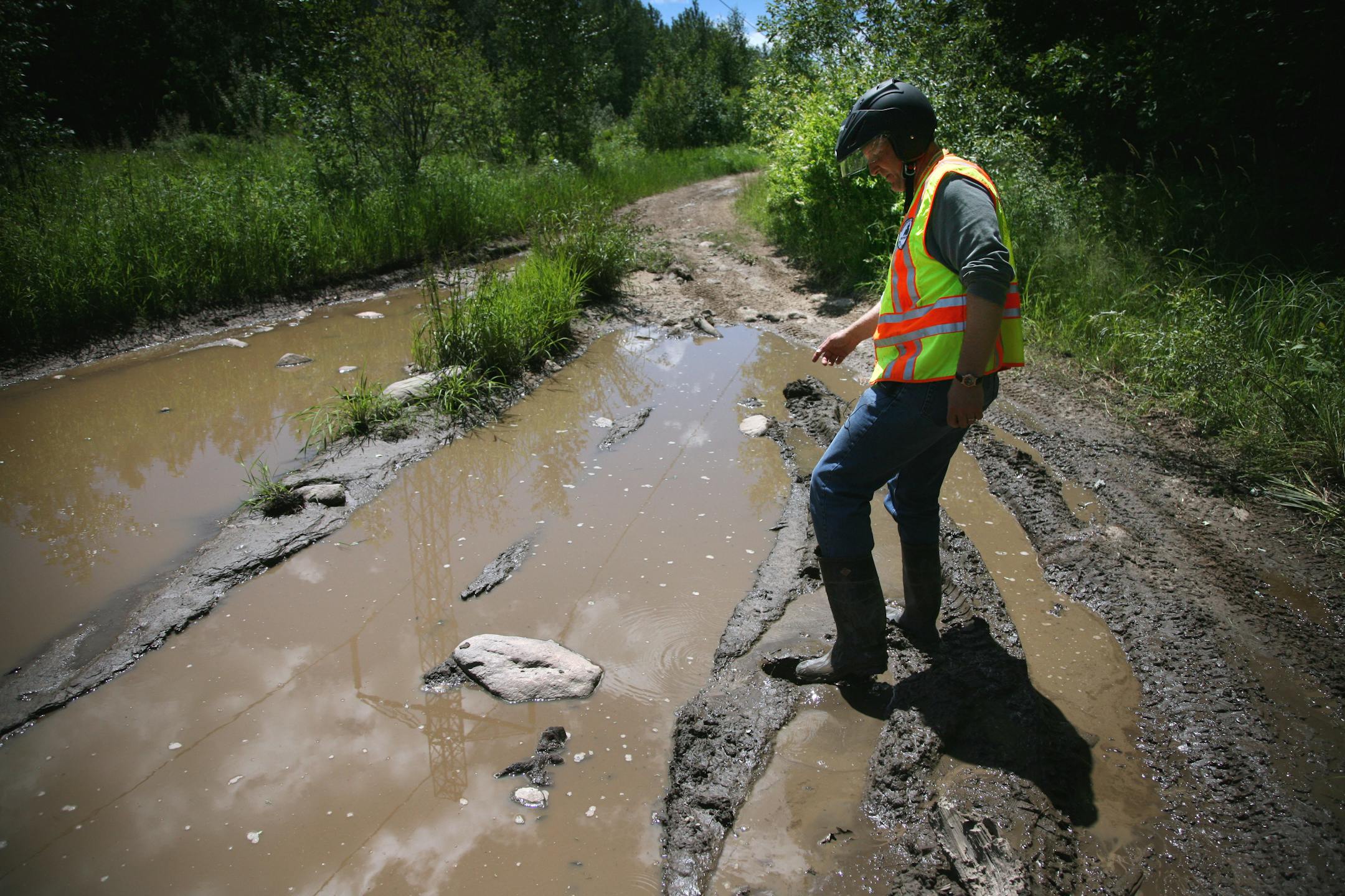 Trail Ambassador Perry May checks an area of "trail braiding" where riders widen out a spot on the trail by trying to avoid the deep water. May flagged this area and marked the spot on his GPS for future repair by the DNR.
