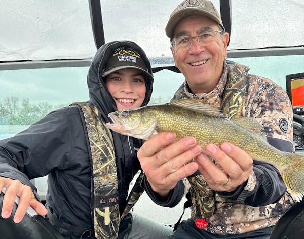 Scott Ward of Inver Grove Heights. right, and Jack Kennedy of Cottage Grove with an Opening Day walleye from Lake Sarah in Murray County. 