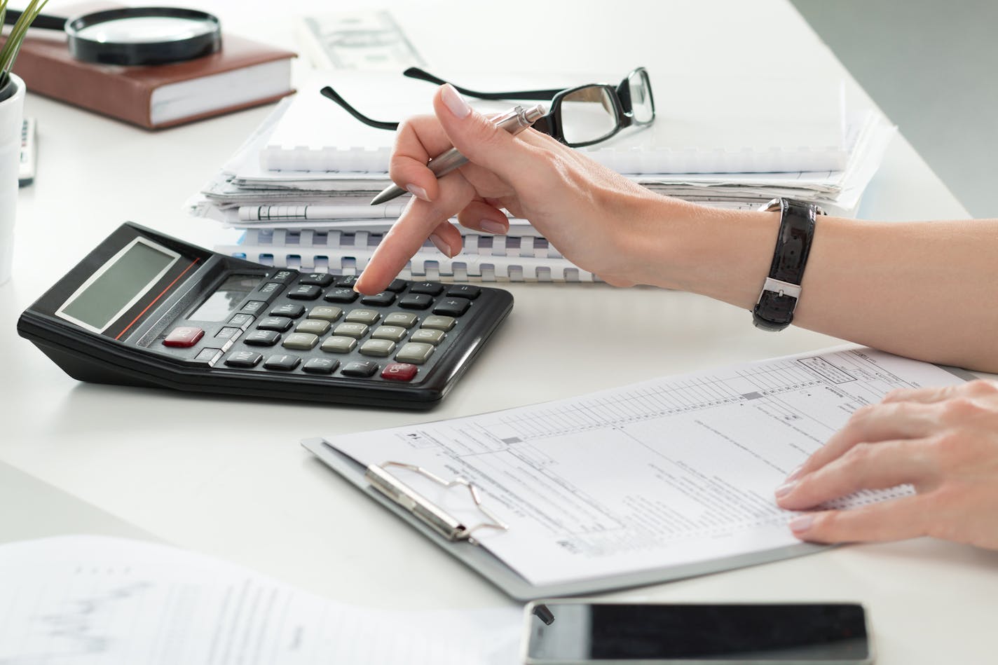 Close up of female accountant or banker making calculations. Savings, finances and economy concept. istock