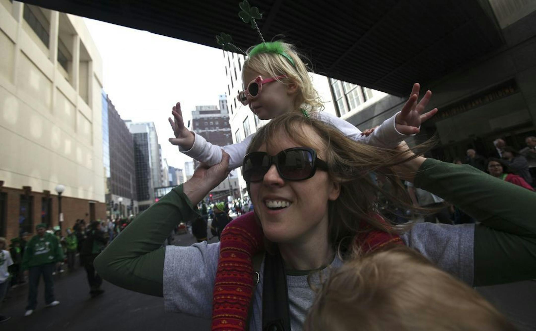 Stefanie McAlpine walked the parade route with her daughter Eleanor, 3, on her shoulders and he youngest Louisa, 1, strapped in a baby carrier along Fourth Street in St. Paul for the St. Patrick's Day parade.