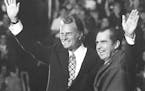 FILE - In this Oct. 16, 1971 file photo, Evangelist Billy Graham and President Nixon wave to a crowd of 12,500 at ceremonies honoring Graham at Charlo