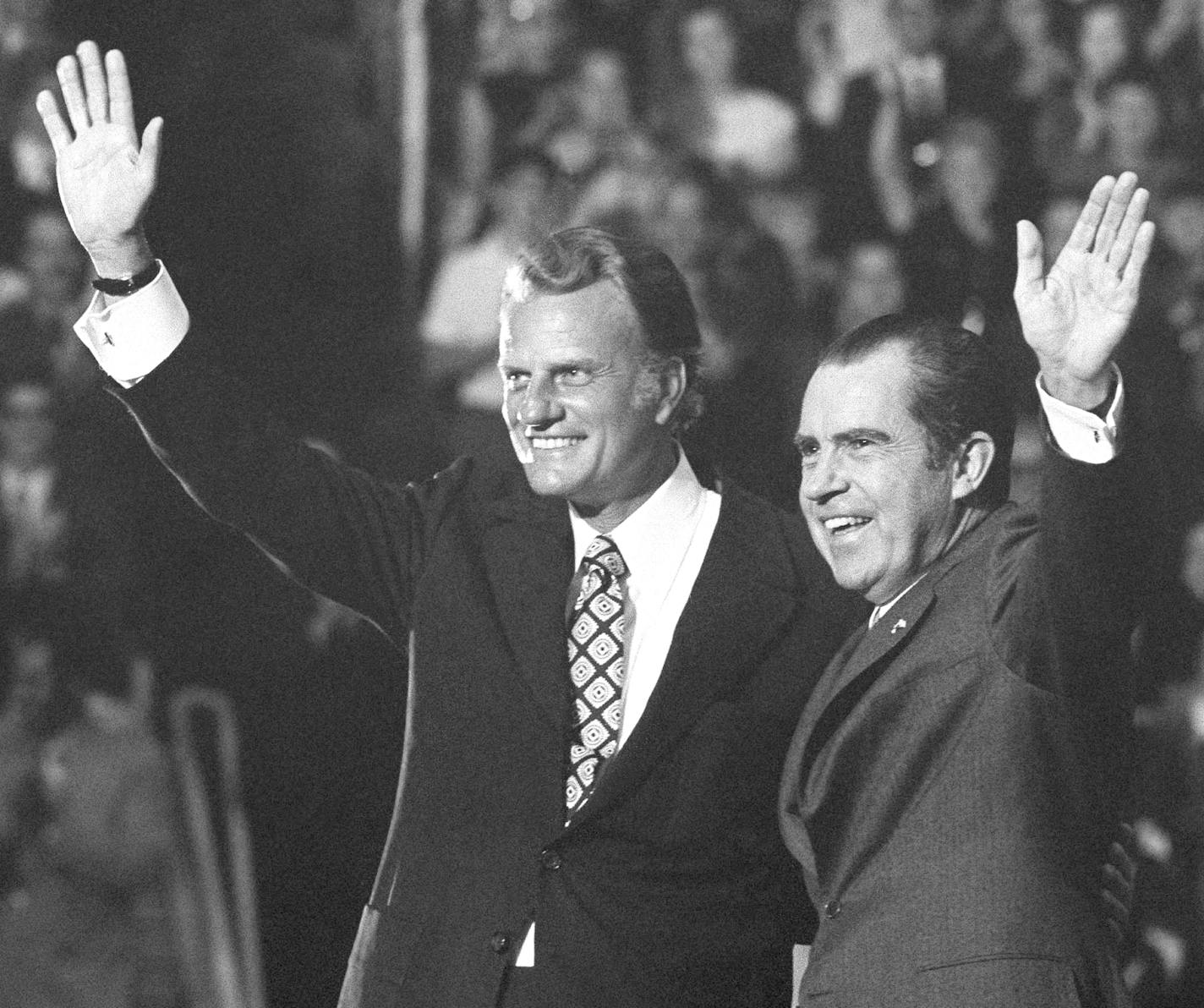 FILE - In this Oct. 16, 1971 file photo, Evangelist Billy Graham and President Nixon wave to a crowd of 12,500 at ceremonies honoring Graham at Charlotte, N.C. Graham, who transformed American religious life through his preaching and activism, becoming a counselor to presidents and the most widely heard Christian evangelist in history, has died. Spokesman Mark DeMoss says Graham, who long suffered from cancer, pneumonia and other ailments, died at his home in North Carolina on Wednesday, Feb. 21