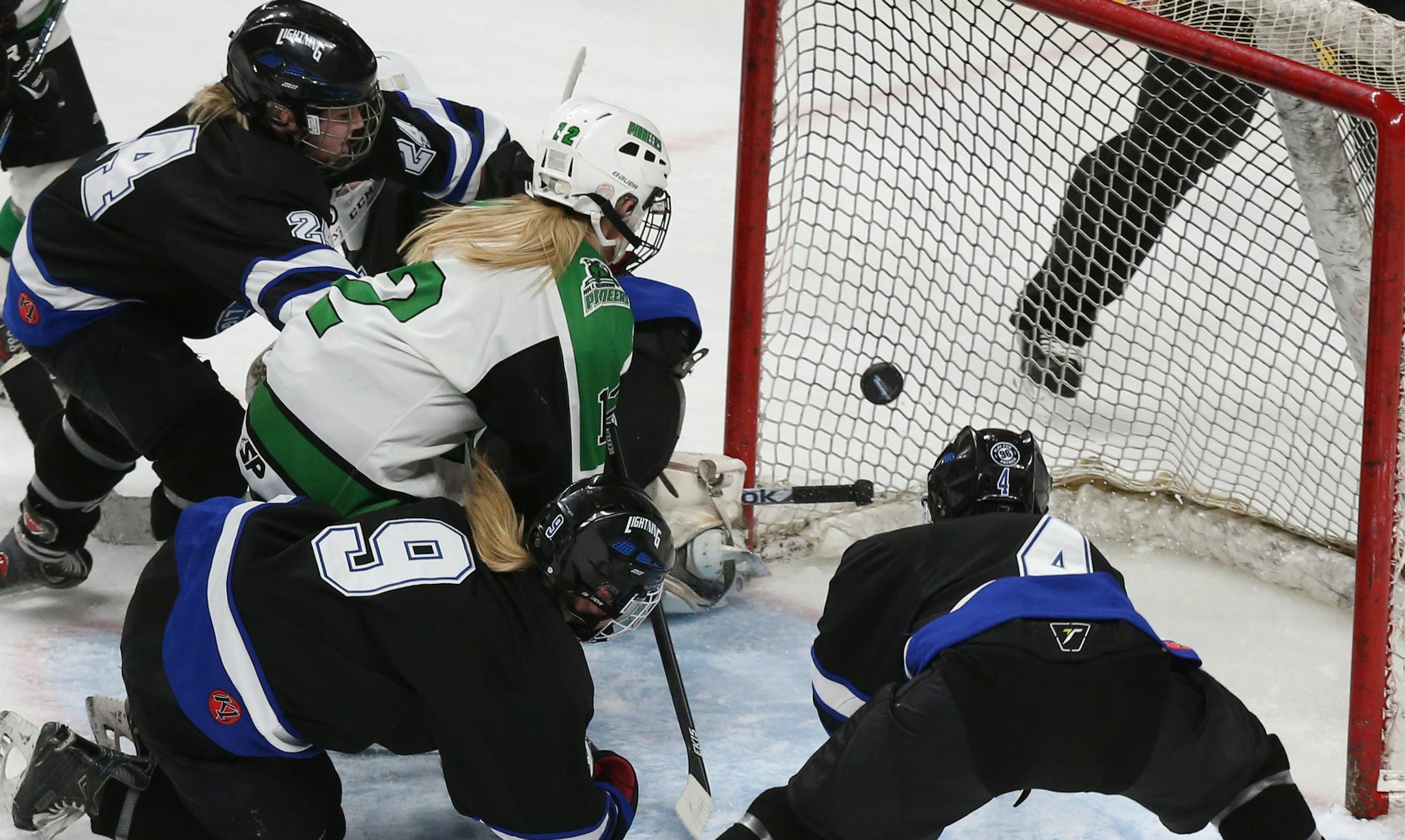 Hill-Murray's Morgan Helgeson (12) made a shot in traffic toward the open net against Eastview's goalie Kaityln Pellicci (31) during the second period. ] (KYNDELL HARKNESS/STAR TRIBUNE) kyndell.harkness@startribune.com Girls' hockey state tournament. Eastview vs. Hill-Murray Thursday, Feb. 23, 2016 at the Xcel Energy Center in St. Paul, Min.