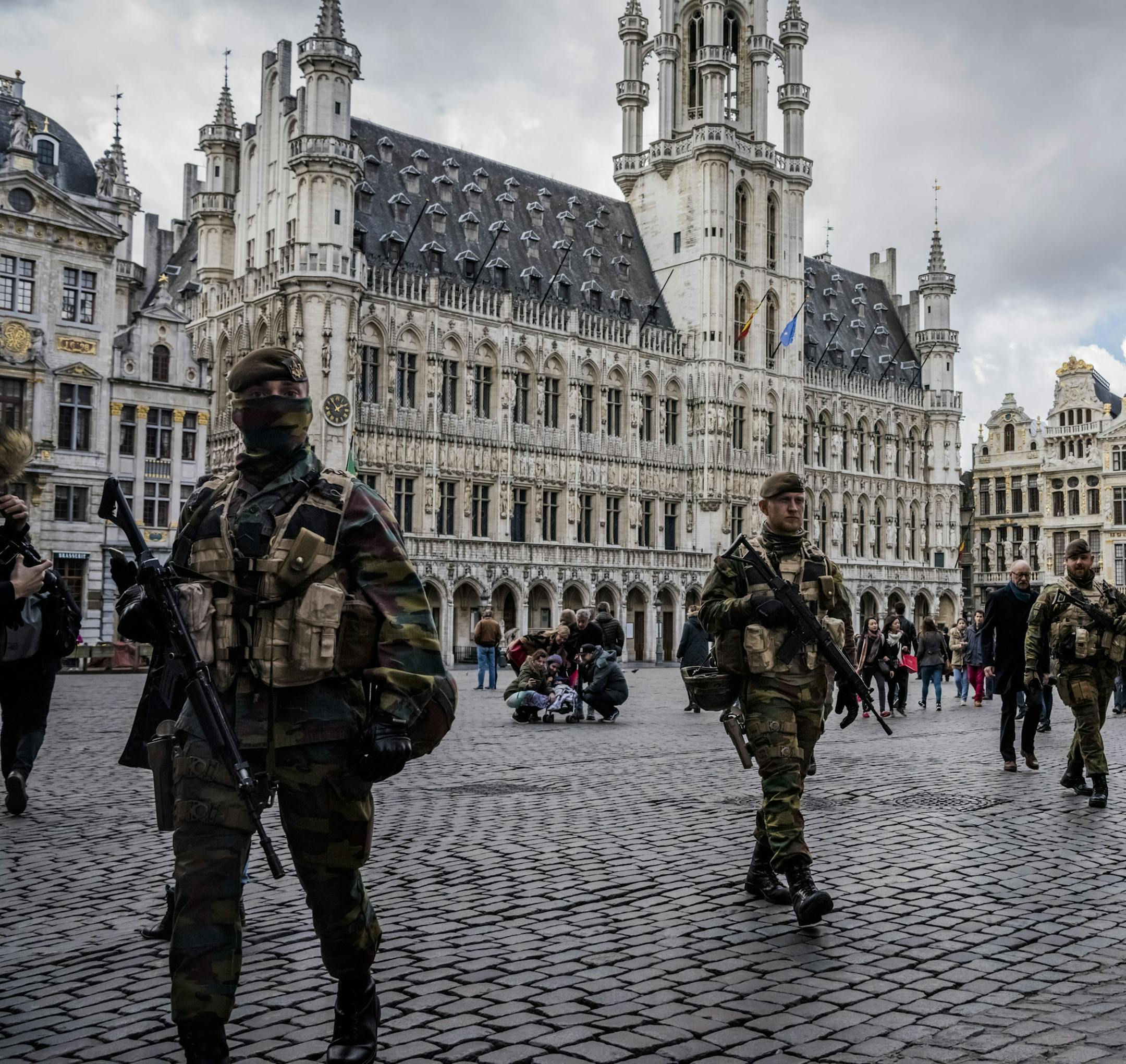 Belgian soldiers patrol Grand Place in Brussels, close to Place de la Bourse where people gathered at a makeshift memorial for victims of Tuesday's attacks, March 27, 2016. In another blunder acknowledged after the bombings, Belgian authorities said Monday that they had misidentified a man arrested as the missing suspect shown in an airport surveillance photo. The man, arrested on Thursday and charged on Friday, was released after three days in custody, during which some officials publicly vilif