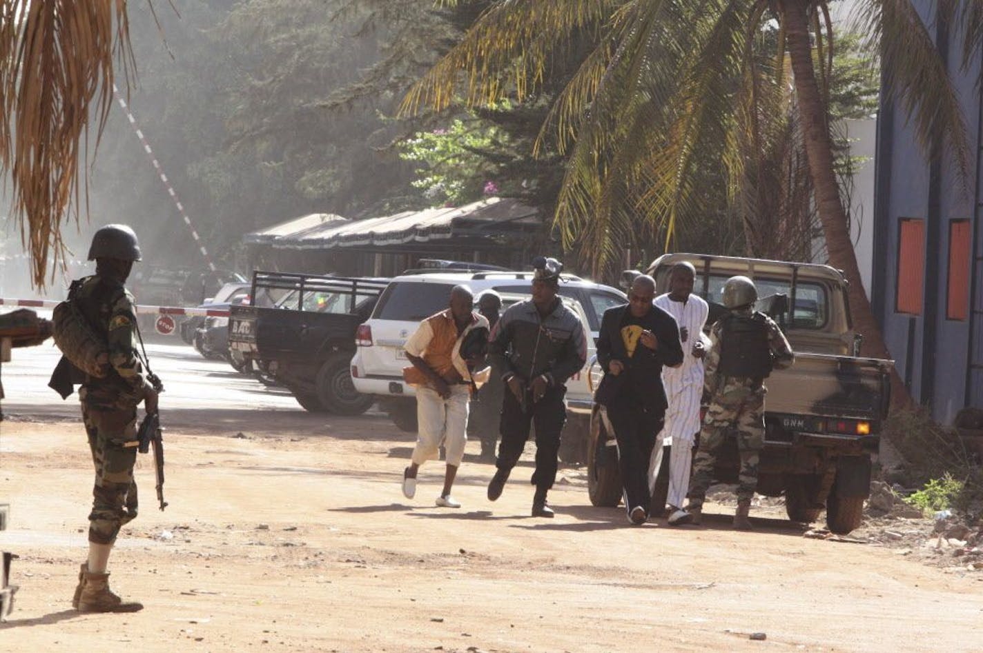 People run to flee from the Radisson Blu Hotel in Bamako, Mali, Friday, Nov. 20, 2015. The company that runs the Radisson Blu Hotel in Mali's capital says assailants have takenhostages in a brazen assault involving grenades.