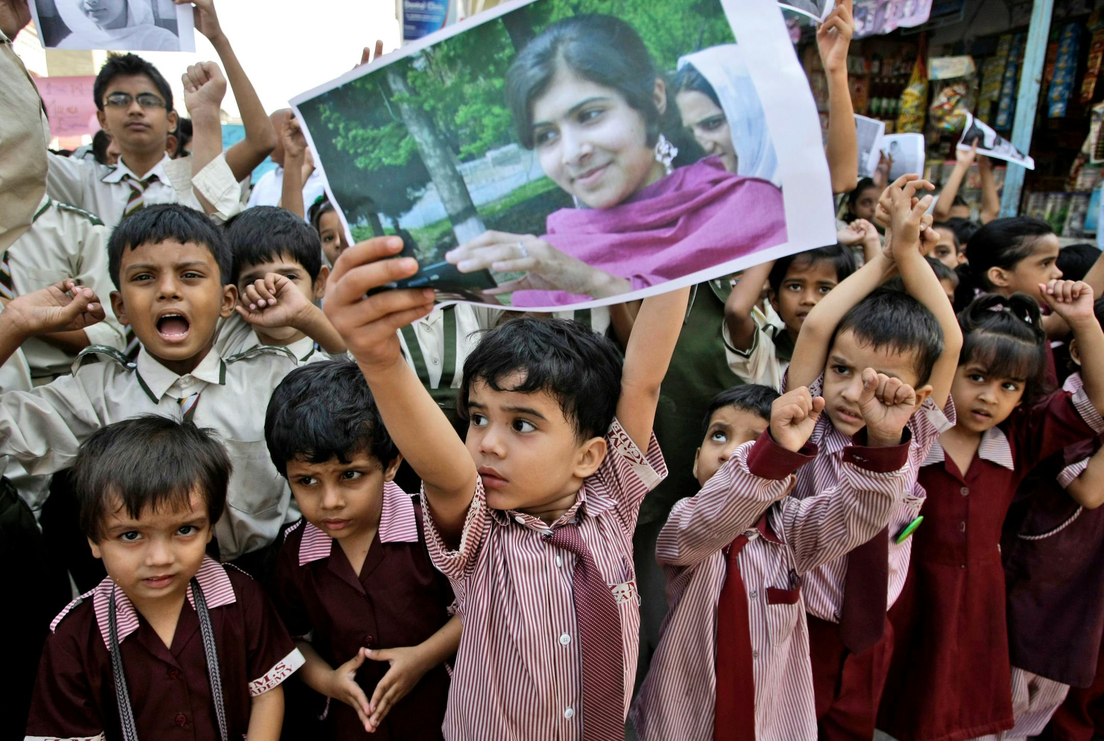 A Pakistani boy holds up a picture of 14-year-old schoolgirl Malala Yousufzai, who was shot last Tuesday by the Taliban for speaking out in support of education for women, while he and other schoolchildren attend a protest condemning the attack, in Karachi, Pakistan, Saturday, Oct. 13, 2012. (AP Photo/Fareed Khan)