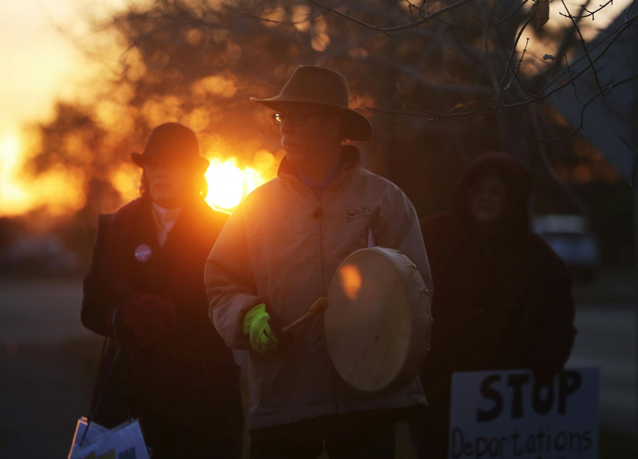 As the morning sun rose, Stefan Sylvander of St. Paul, carried his drum as he joined other protestors outside the Whipple Federal Building Tuesday, Oct. 29, 2019, in St. Paul, MN. Clergy and protestors gathered for a service and communion outside the Whipple Federal Building and to protest the naming of the building after the Episcopal bishop because deportations and other actions at the courthouse are in opposition to the beliefs of the Episcopal church, they stated.