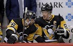 Pittsburgh Penguins' Sidney Crosby (87) talks with Jason Zucker (16) during the first period of an NHL hockey game against the Tampa Bay Lightning in 