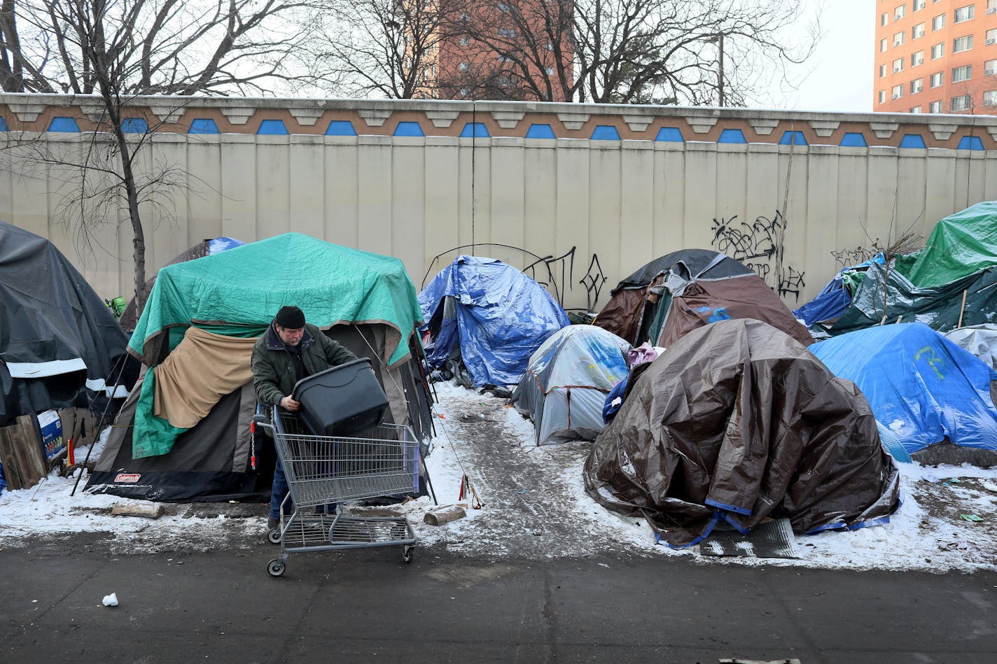 It was moving day for some at the Hiawatha homeless encampment and a day of joy and emotion for some Tuesday, Dec. 11, 2018, in Minneapolis, MN. Here, resident James Loerzel, 59, who has lived at the camp for about three months, loads up a shopping cart with personal belongings from his tent before he moved to the new navigation center site. Loerzel said he was looking forward to the move, especially being in a heated place.] DAVID JOLES &#x2022; david.joles@startribune.com About a dozen residen