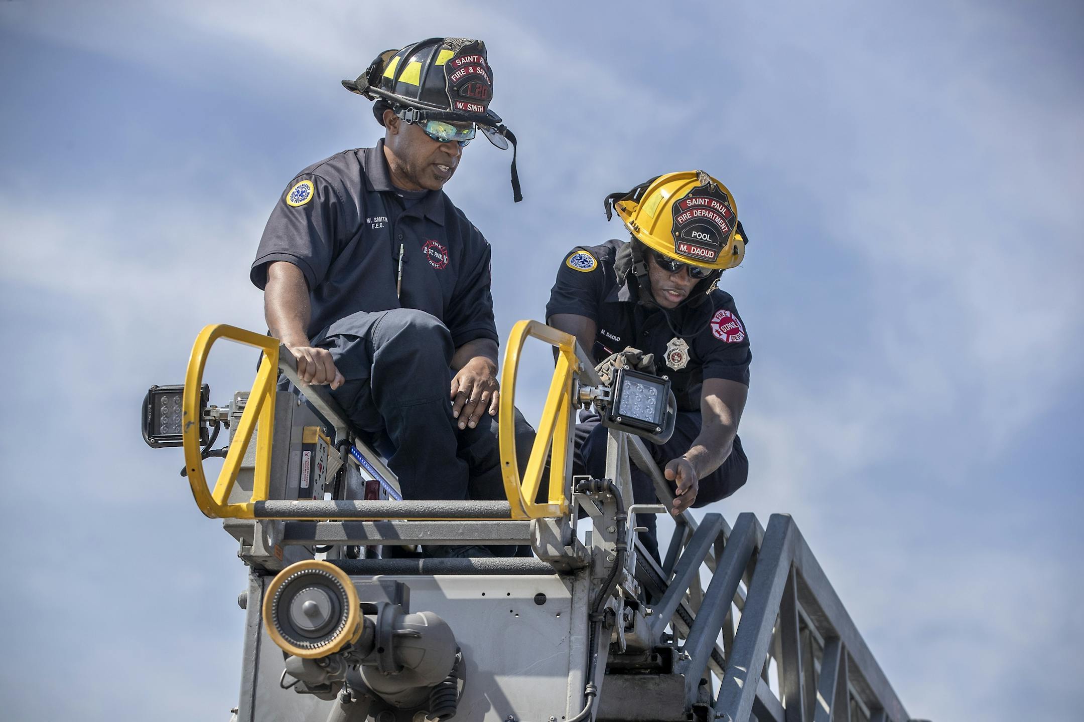 St. Paul firefighter Mohamed Daoud, right, learned how work the ladder on Ladder 23 by FEO Will Smith, left, during his second day on the job as one of the first Somali Americans to be sworn into the St. Paul fire department.