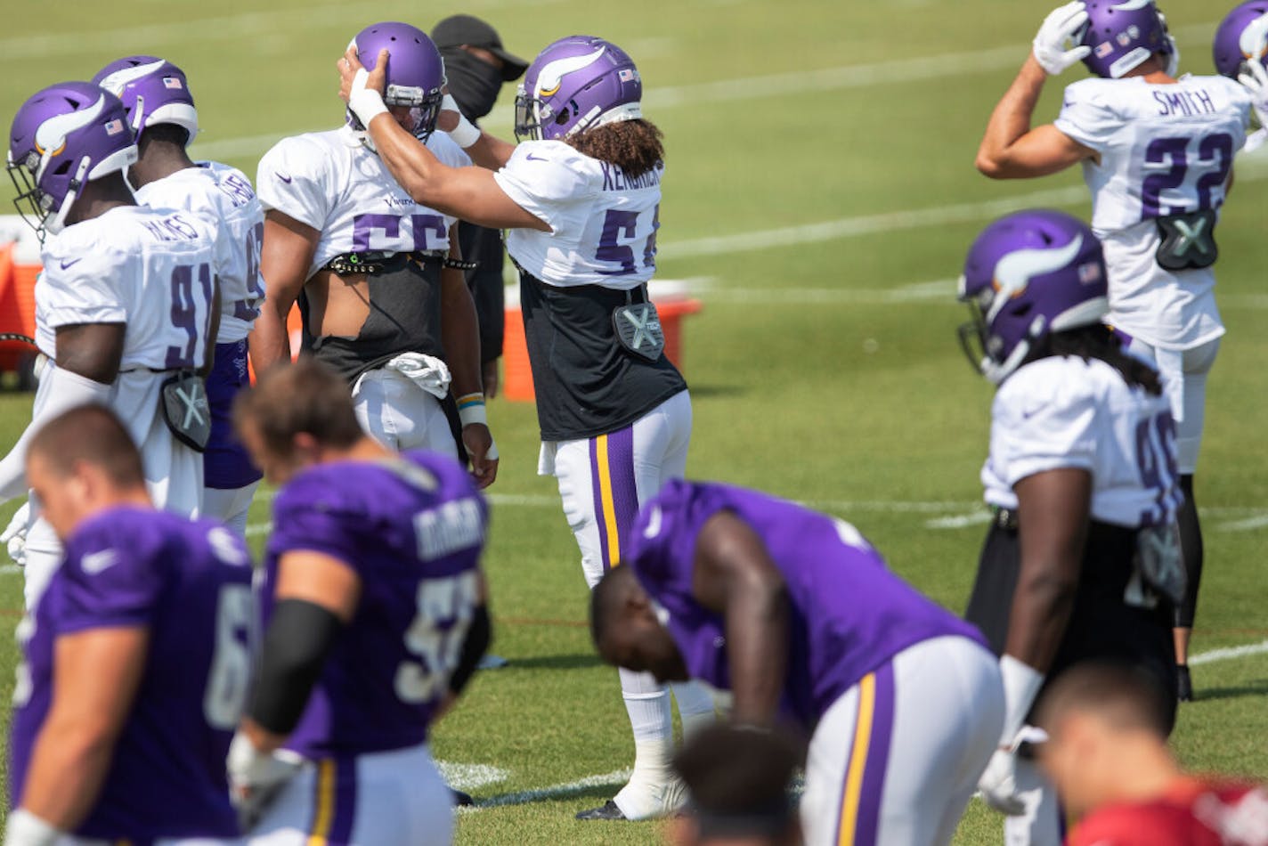 Minnesota Vikings linebacker Eric Kendricks (54) adjusted Anthony Barr (55) helmet at the start of practice on Thursday.