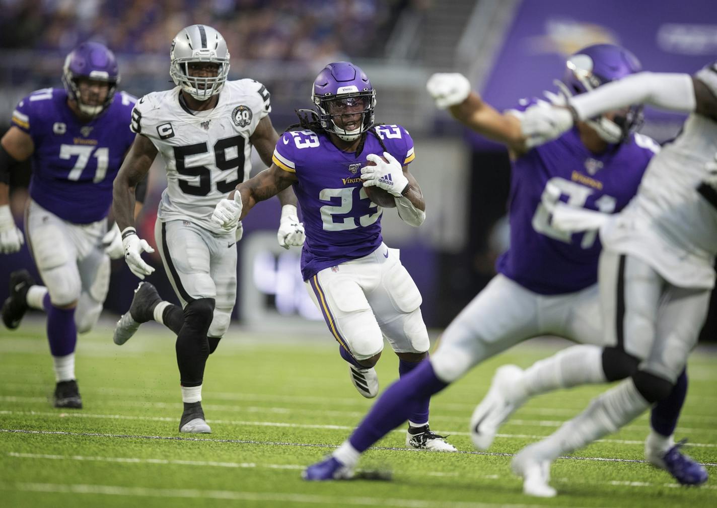 Minnesota Vikings running back Mike Boone (23) made a cut against Oakland Raiders outside linebacker Tahir Whitehead (59) picking up a first down on the play in the fourth quarter .