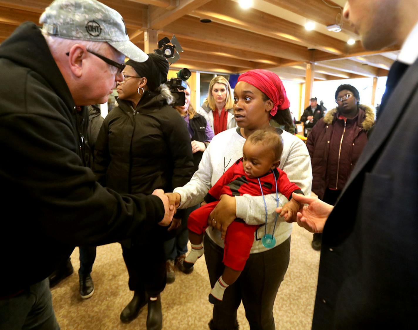 Minnesota Gov. Tim Walz, left, and Minneapolis Mayor Jacob Frey, right, met with displaced Francis Drake Hotel residents at Bethlehem Baptist Church, including Nicole Robertson, holding her son Chartez Williams, 6 months. DAVID JOLES • david.joles@startribune.com Followup of the Christmas Day fire at Francis Drake Hotel apartments.**MN.**Nicole Robertson, Chartez Williams,cq