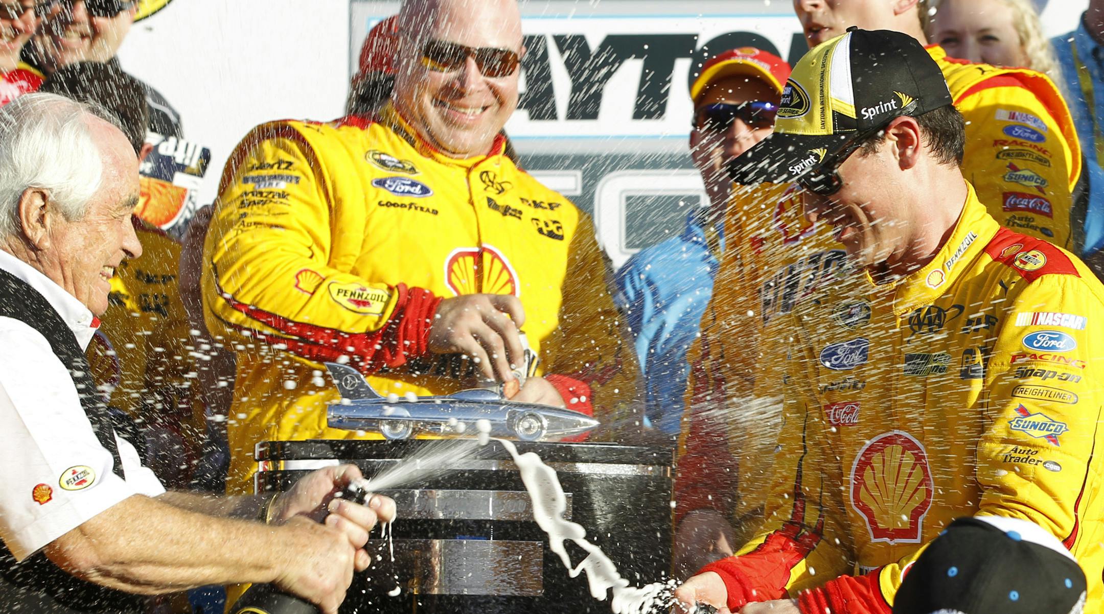 Joey Logano, right, celebrates with team owner Roger Penske, left, after winning the Daytona 500 NASCAR Sprint Cup series auto race at Daytona International Speedway, Sunday, Feb. 22, 2015, in Daytona Beach, Fla. (AP Photo/Terry Renna) ORG XMIT: DBR138