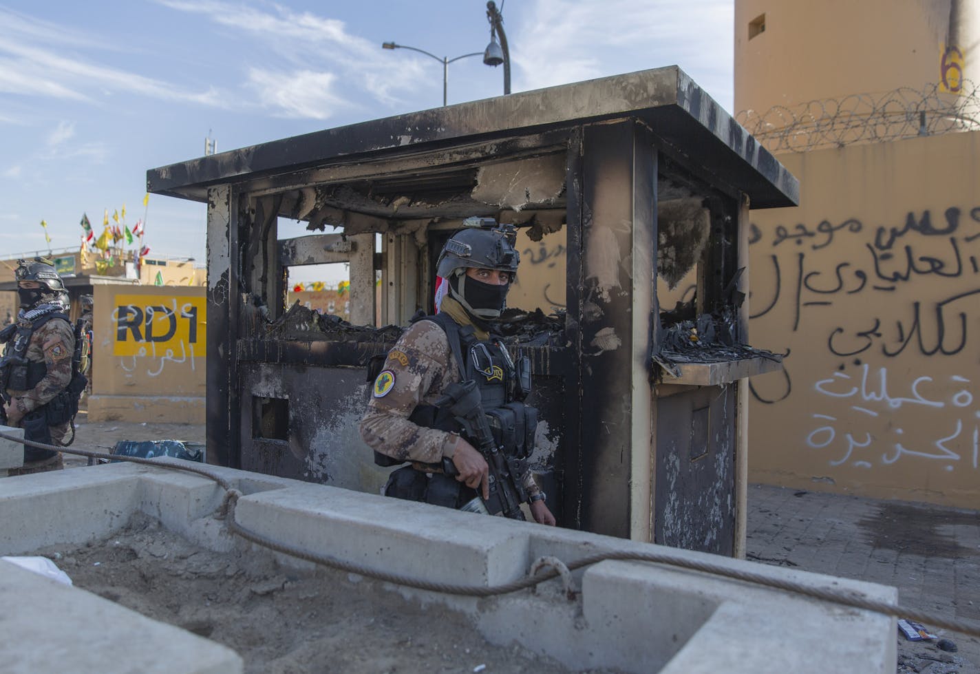 FILE - In this Jan. 1, 2020 file photo, Iraqi army soldiers are deployed in front of the U.S. embassy, in Baghdad, Iraq. U.S. and Iraqi officials on Thursday, Dec. 3, say the U.S. is withdrawing some staff from its embassy in Baghdad, temporarily reducing personnel amid regional security concerns. U.S. Ambassador Mathew Tueller said the reduction of staff members will not affect the mission's work, adding that he will continue to carry out his duties from the embassy for the "foreseeable future.