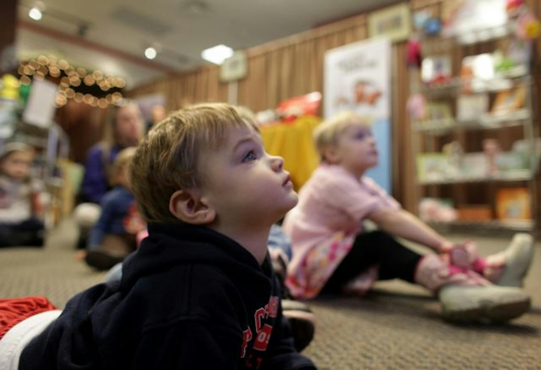 Nicholas Burroughs, 2, of Chanhassen, listened to children's author Gordon W. Fredrickson readi his book "A Farm Country Christmas Eve" at the Bye Bye Bookstore and the Eden Prairie Center.