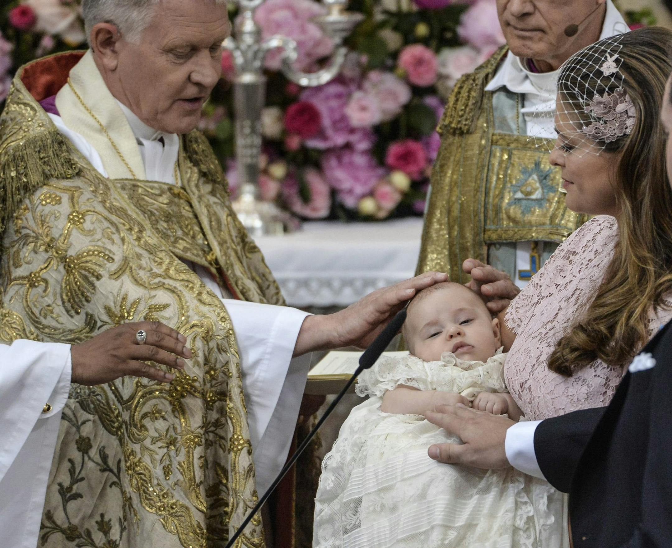 Archbishop Anders Wejryd, left, baptizes Princess Leonore held by her mother Princess Madeleine and father Christopher O'Neill, right, during the christening ceremony in the Drottningholm Palace church outside Stockholm, Sweden, Sunday, June 8, 2014. (AP Photo/TT, Jonas Ekstromer) SWEDEN OUT