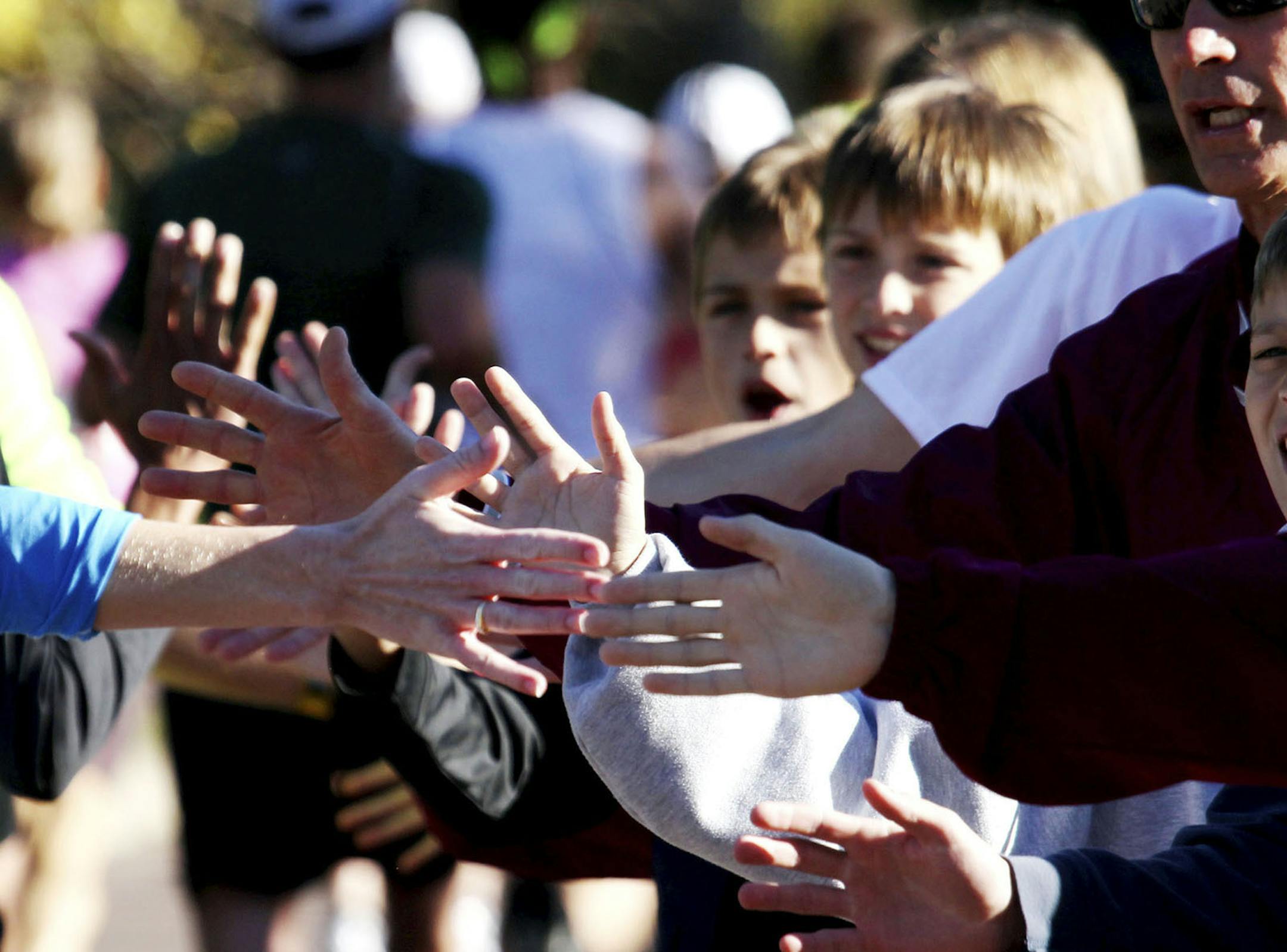 DAVID JOLES ¬• djoles@startribune.com - Oct. 3, 2010 - Minneapolis, MN - ] Sunny skies and crisp temps greeted Twin Cities Marathon runners and fans along the 26.2 mile route that wound its way through Minneapolis en route to the finnish in St. Paul. In this photo:] Members of the Mountain Lake High cross country team give out high fives to runners near the halfway point along Lake Nokomis. "Feel the energy," some said. "Feel the love." ORG XMIT: MIN2013100717472960