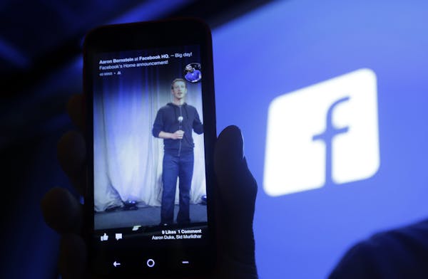 In this Thursday, April 4, 2013, photo, Michael Goodwin, Senior Partner for HTC, displays an HTC First cell phone with the new Facebook interface at F