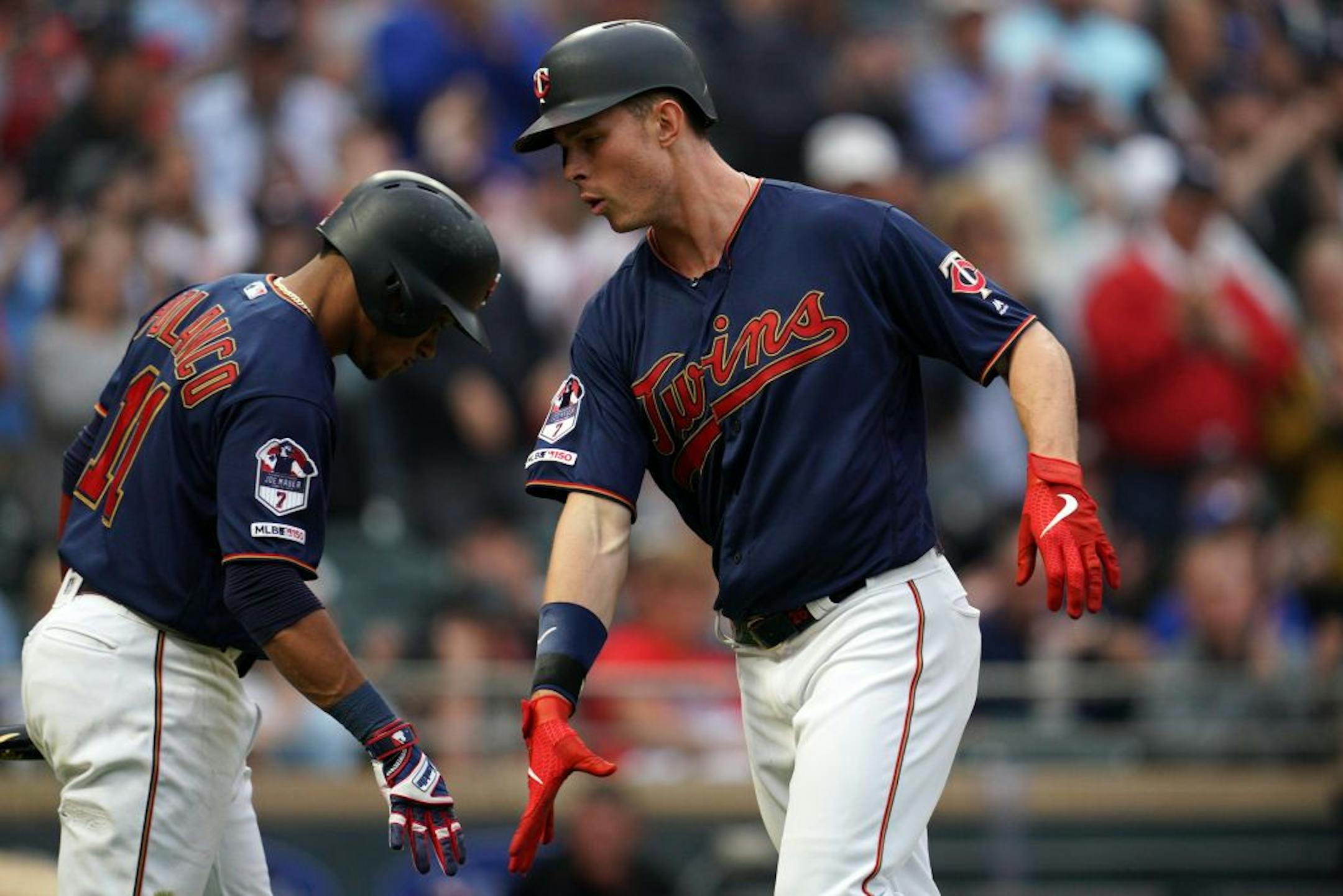Minnesota Twins right fielder Max Kepler (26) celebrated with Minnesota Twins shortstop Jorge Polanco (11) as he crossed home plate after hitting a home run in the fourth inning.