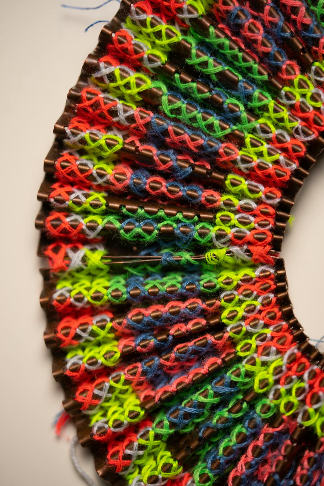 A detail of a necklace made of pleated copper and embroidery that was inspired by a traditional Hmong pleated skirt. The piece was crafted by visual artist Ger Xiong.
