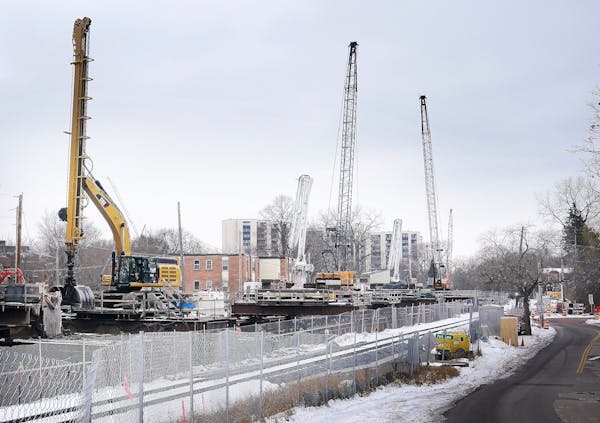 Cranes and other heavy equipment last month at the construction site of a tunnel along the Kenilworth Corridor in Minneapolis between Lake of the Isle