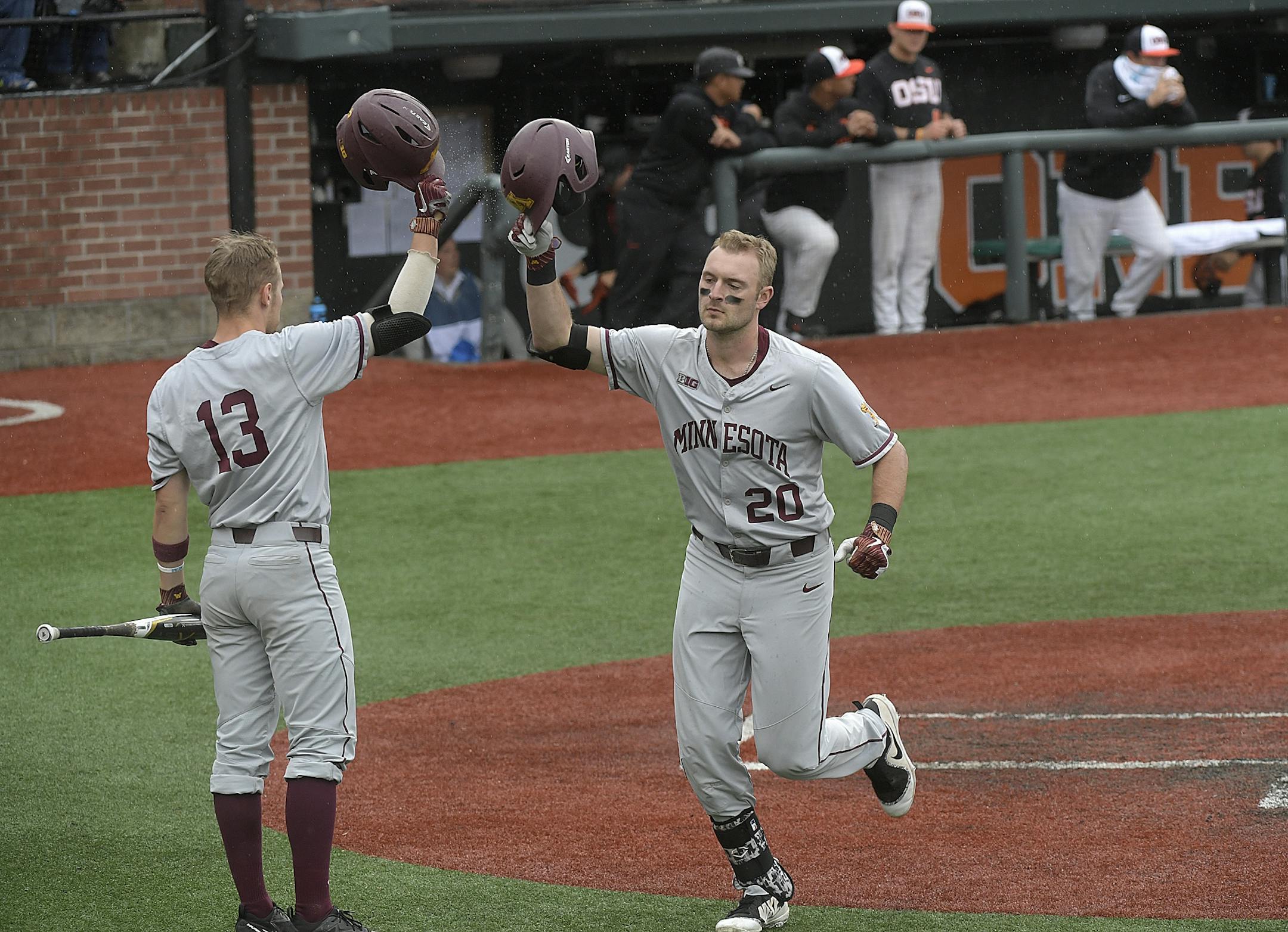 Minnesota's Toby Hanson (20) taps helmets with Luke Pettersen (13) after Hanson hit a solo home run off Oregon State's Luke Heimlich during the opening game of an NCAA college baseball tournament super regional in Corvallis, Ore., Friday, June 8, 2018.