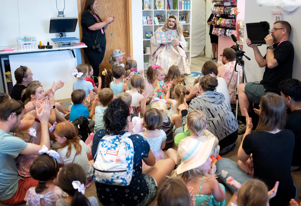 While Minnesota Proud Boys protested outside, Miz Diagnosis, a drag queen from Chaska read children's books to parents and kids inside Little Roos clo