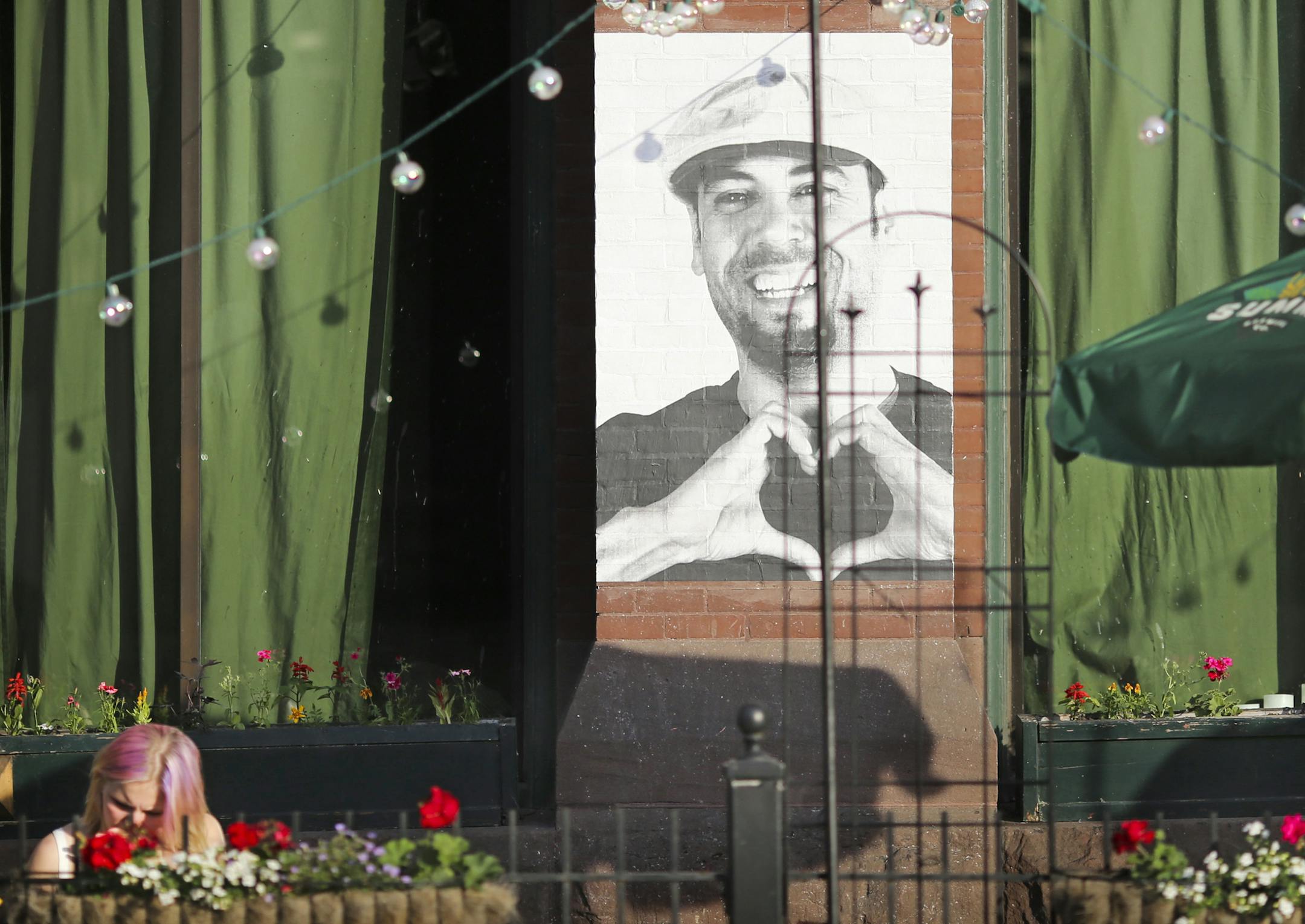 Diners ate next to a portrait photographs that is displayed on Black Dog Wine and Coffee Bar in Lowertown as part of the Inside Out project in St. Paul, Minn. on Thursday, May 28, 2015. ] RENEE JONES SCHNEIDER ï reneejones@startribune.com The big, black-and-white head shorts are part of an international participatory art project founded by a French artist who goes by the moniker JR. Nearly 200,000 people from more than 100 countries and territories have collaborated on projects designed to