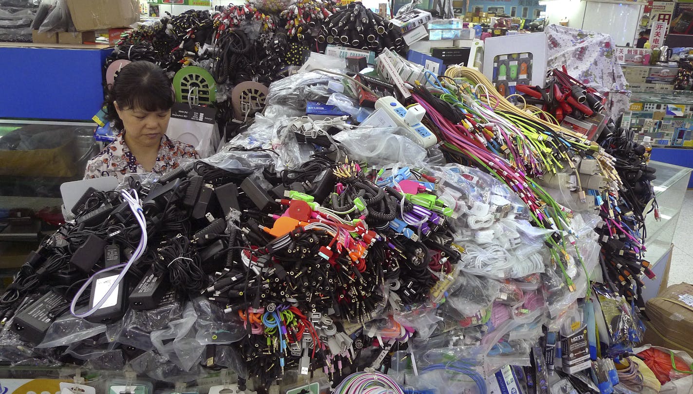 In this Thursday, April 22, 2016 photo, a woman tends to her stall selling cables, connectors and other accessories at the Seg electronics market in the Huaqiangbei neighborhood in Shenzhen, China. The southern Chinese city has become a mecca for global hardware startups, many of whom come over with Hax, a startup "accelerator" backed by venture capital fund SOSV that introduces them to the countless component suppliers and factories in and around the city to speed up prototype development. (AP